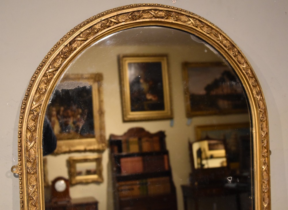 A tall 19th-century full-length mirror featuring an arched gold gilded frame with beaded and foliate moulding. View III