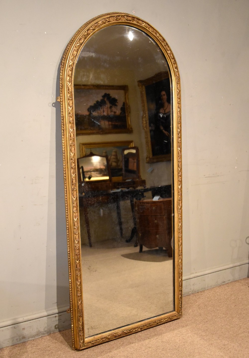 A tall 19th-century full-length mirror featuring an arched gold gilded frame with beaded and foliate moulding. View V