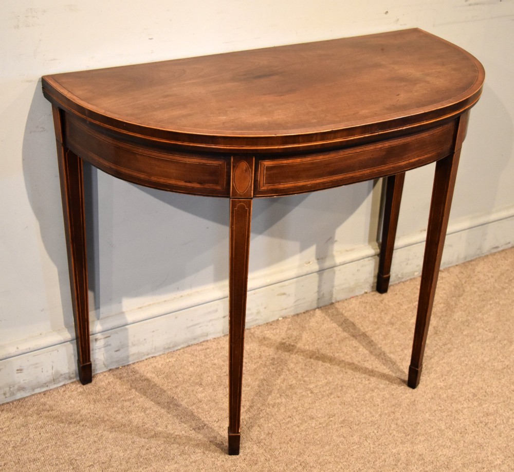 A George III mahogany demi-lune card table featuring boxwood stringing inlay and square tapered legs. View III