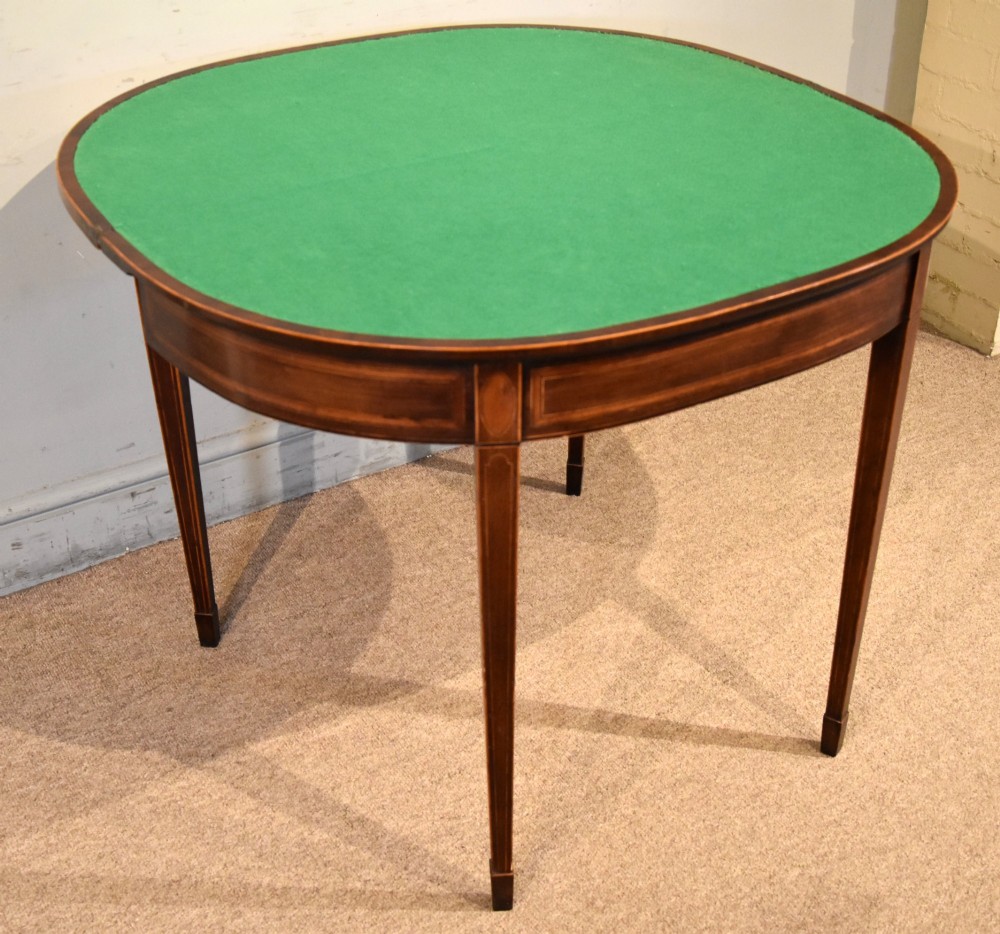 A George III mahogany demi-lune card table featuring boxwood stringing inlay and square tapered legs. View VI
