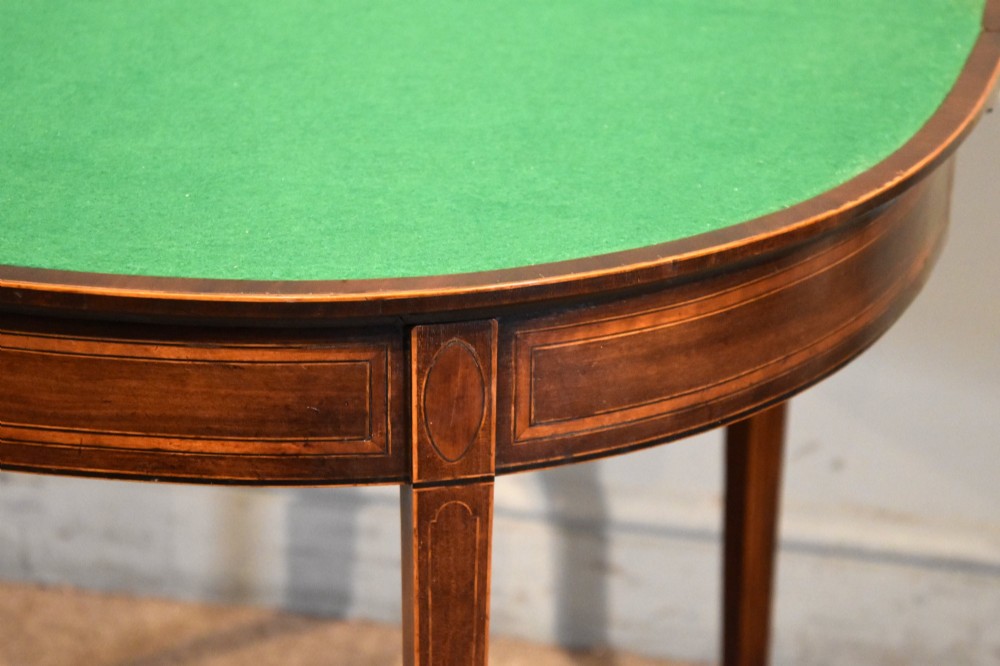 A George III mahogany demi-lune card table featuring boxwood stringing inlay and square tapered legs. View VII