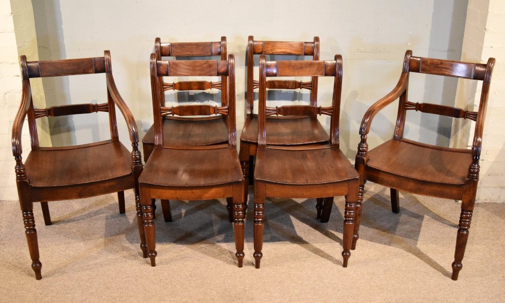 A set of six 19th-century warm brown fruitwood dining chairs comprising two carvers and four side chairs with bar backs and turned front legs.