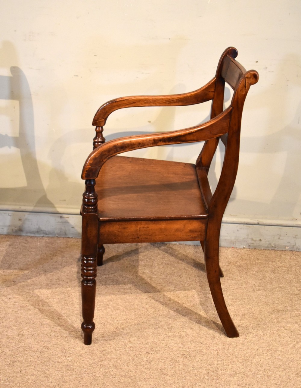 A set of six 19th-century warm brown fruitwood dining chairs comprising two carvers and four side chairs with bar backs and turned front legs. View V