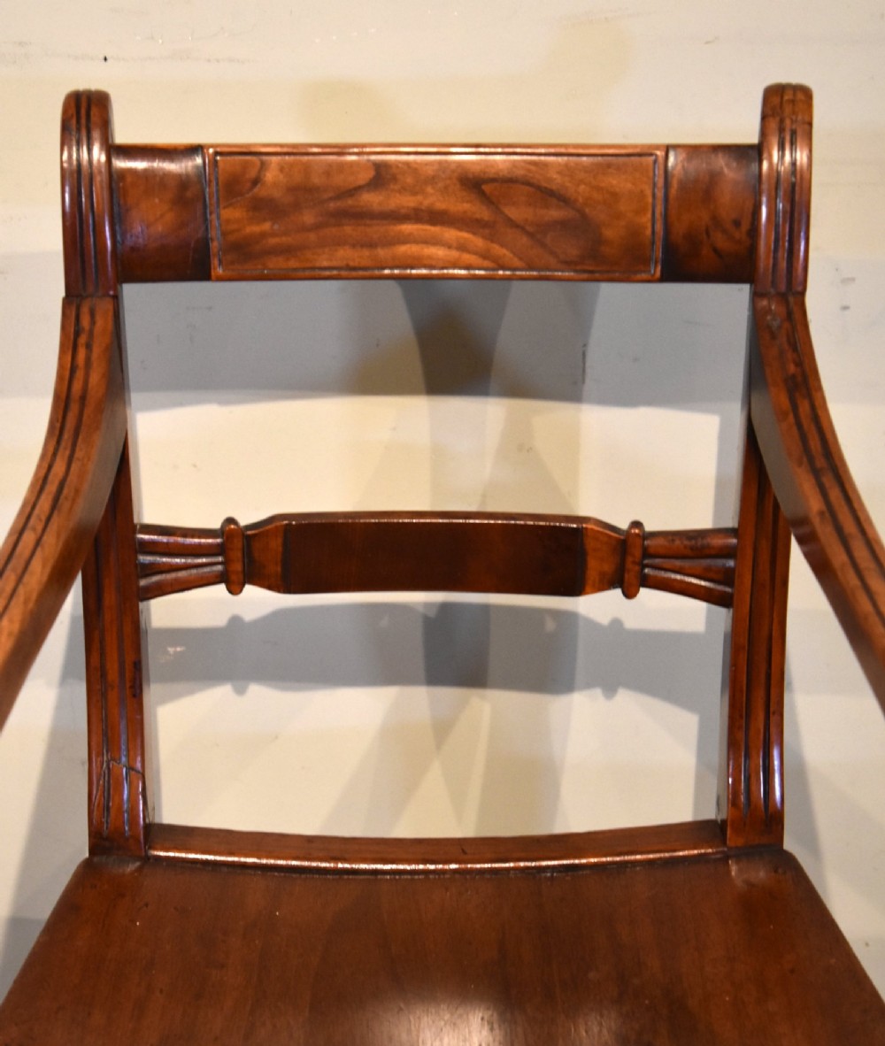 A set of six 19th-century warm brown fruitwood dining chairs comprising two carvers and four side chairs with bar backs and turned front legs. View VI