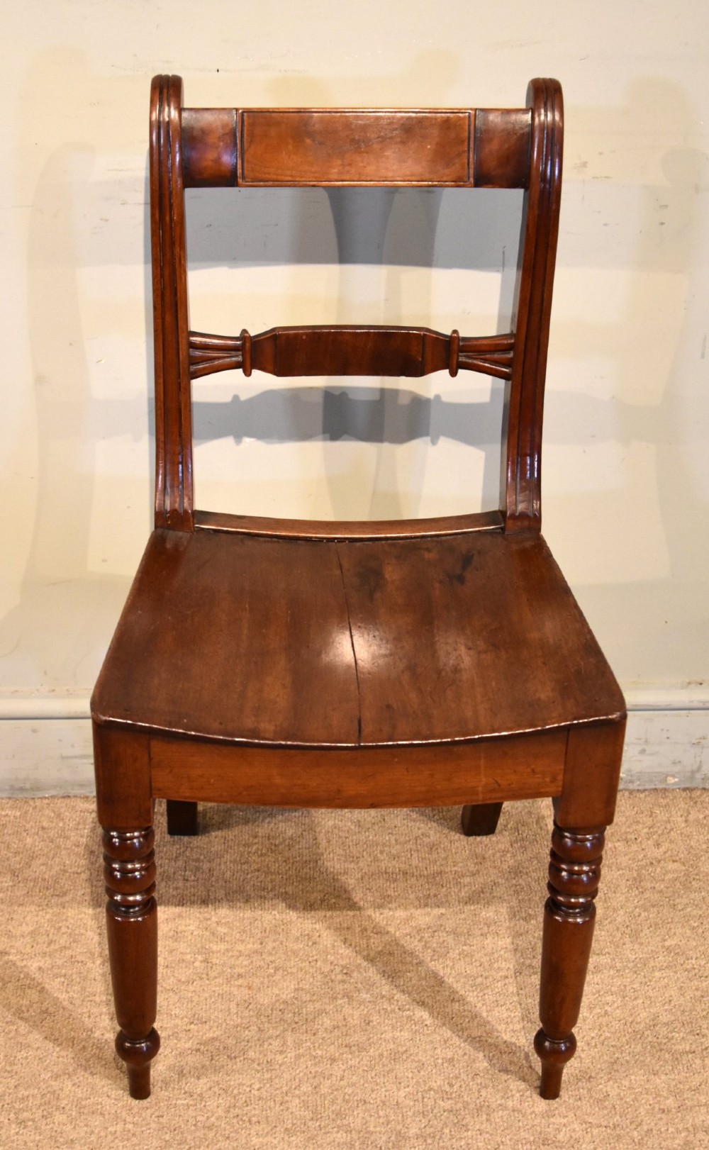 A set of six 19th-century warm brown fruitwood dining chairs comprising two carvers and four side chairs with bar backs and turned front legs. View VII