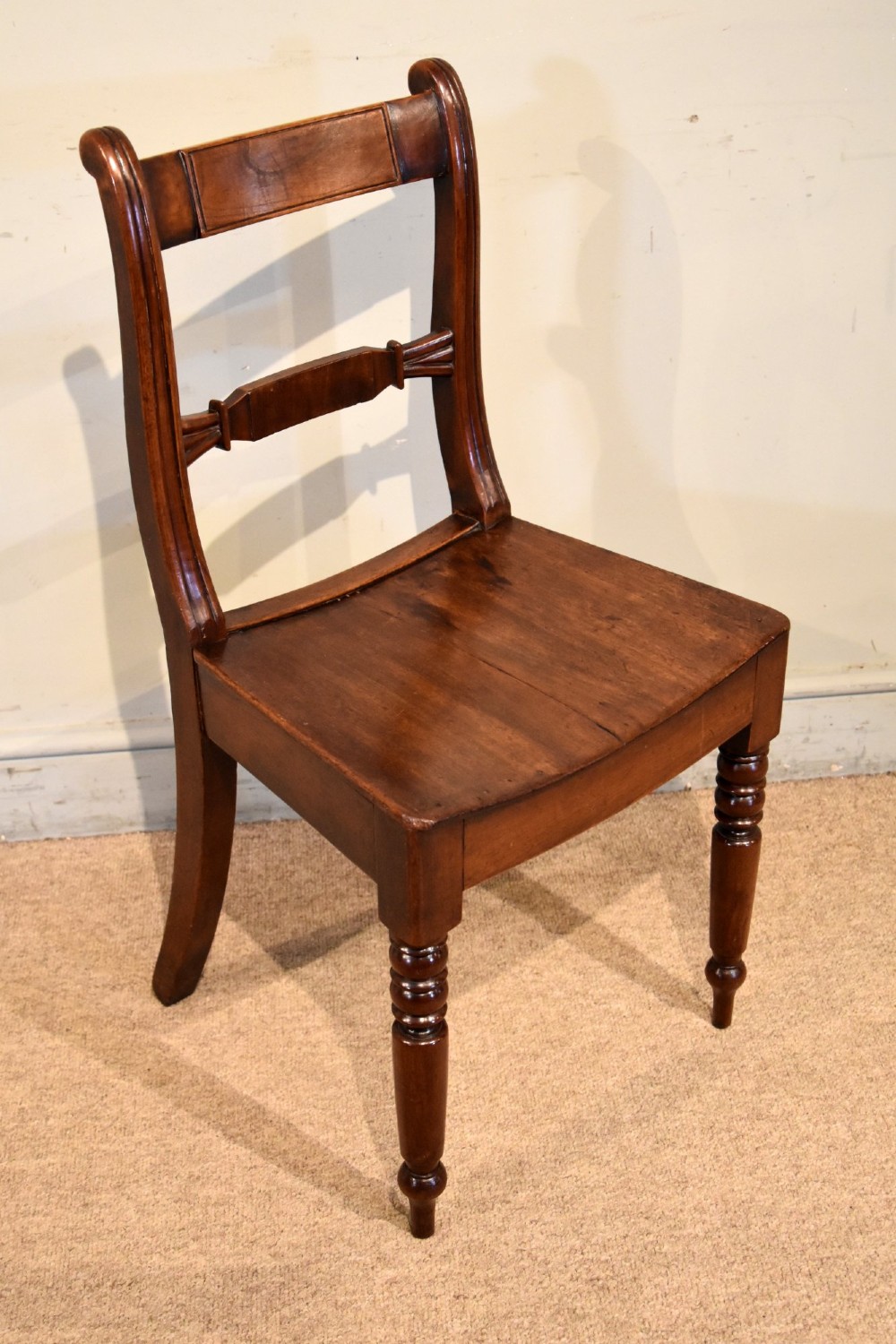 A set of six 19th-century warm brown fruitwood dining chairs comprising two carvers and four side chairs with bar backs and turned front legs. View VIII
