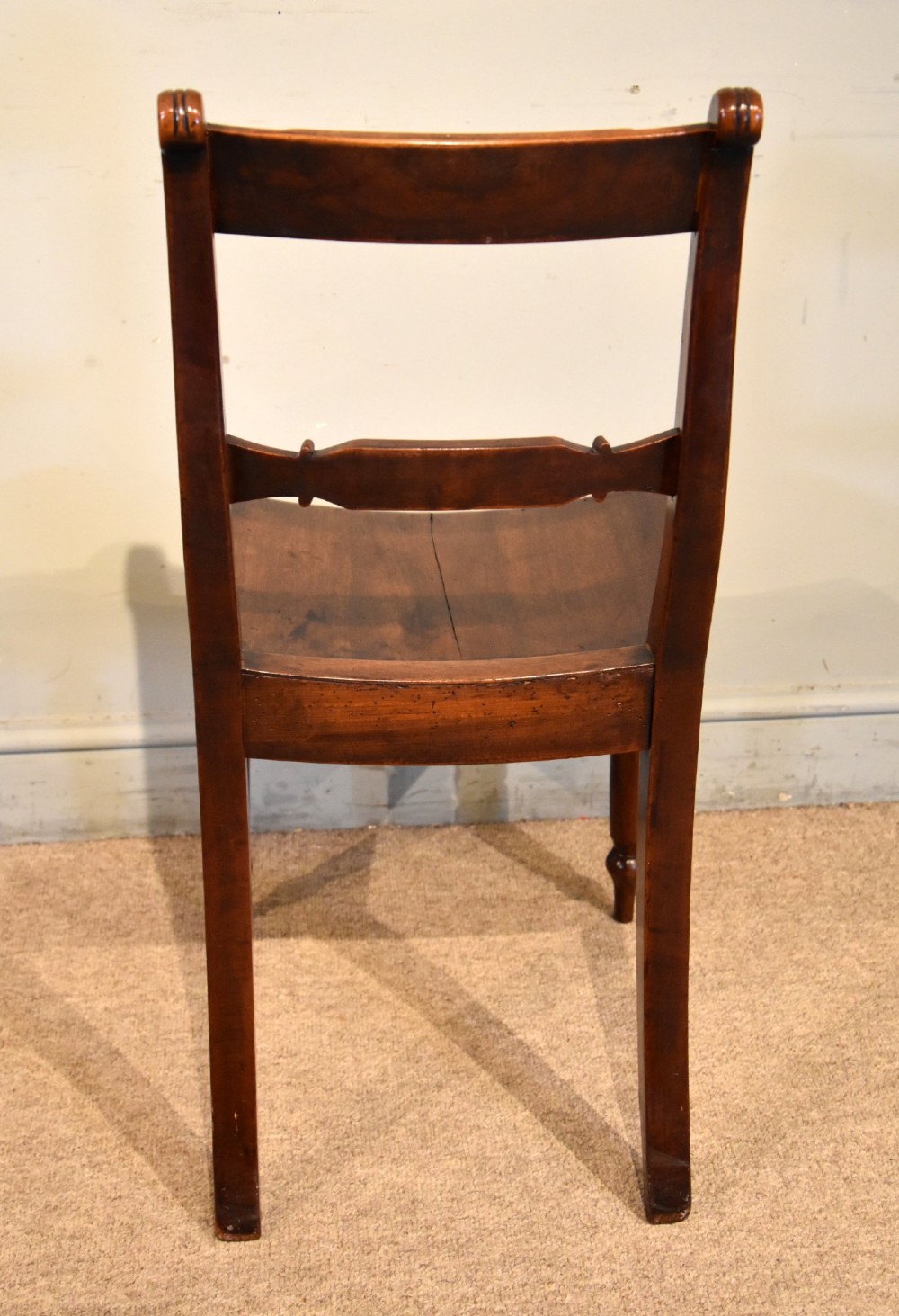 A set of six 19th-century warm brown fruitwood dining chairs comprising two carvers and four side chairs with bar backs and turned front legs. View IX