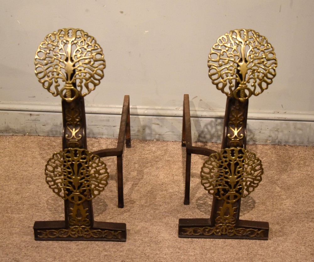A pair of 19th-century brass and cast iron fire dogs featuring pierced circular foliate brass finials on dark iron uprights with horizontal log billets. View III