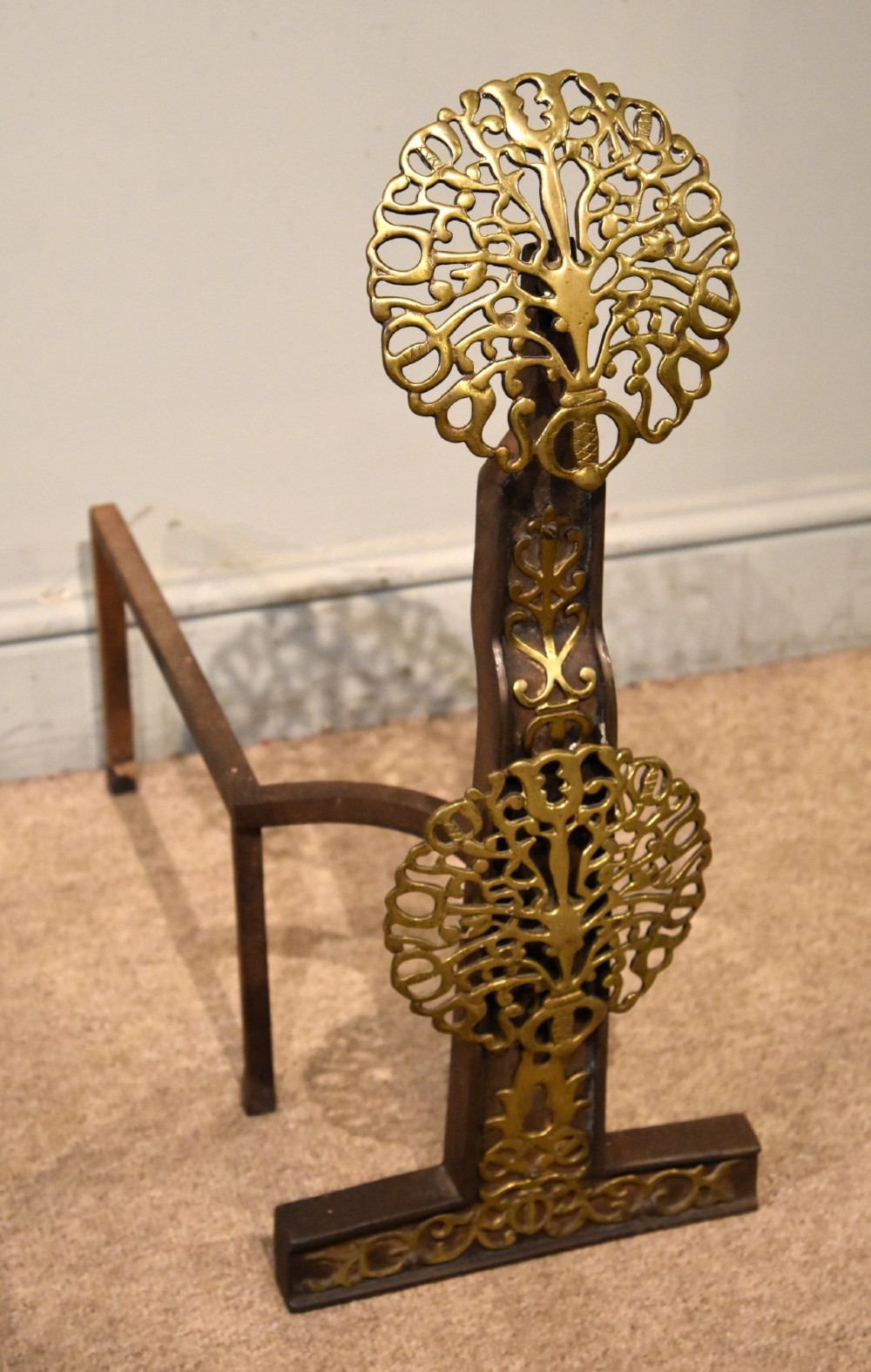 A pair of 19th-century brass and cast iron fire dogs featuring pierced circular foliate brass finials on dark iron uprights with horizontal log billets. View VI