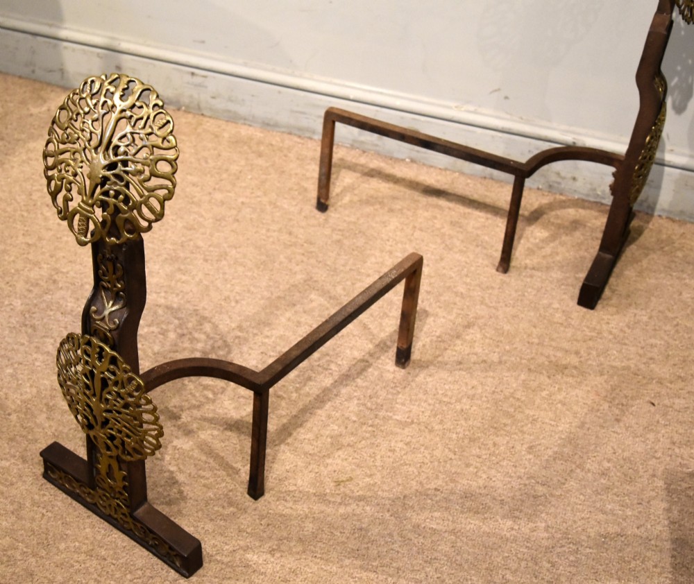 A pair of 19th-century brass and cast iron fire dogs featuring pierced circular foliate brass finials on dark iron uprights with horizontal log billets. View VII