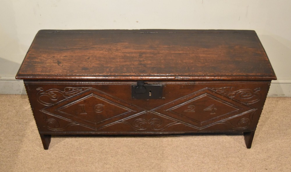 A 17th-century dark oak six-plank coffer featuring carved lozenge patterns containing the date 1624 and a central iron lockplate. View IV