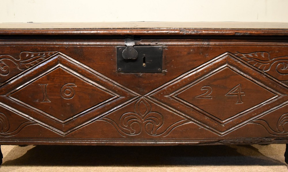 A 17th-century dark oak six-plank coffer featuring carved lozenge patterns containing the date 1624 and a central iron lockplate. View VI