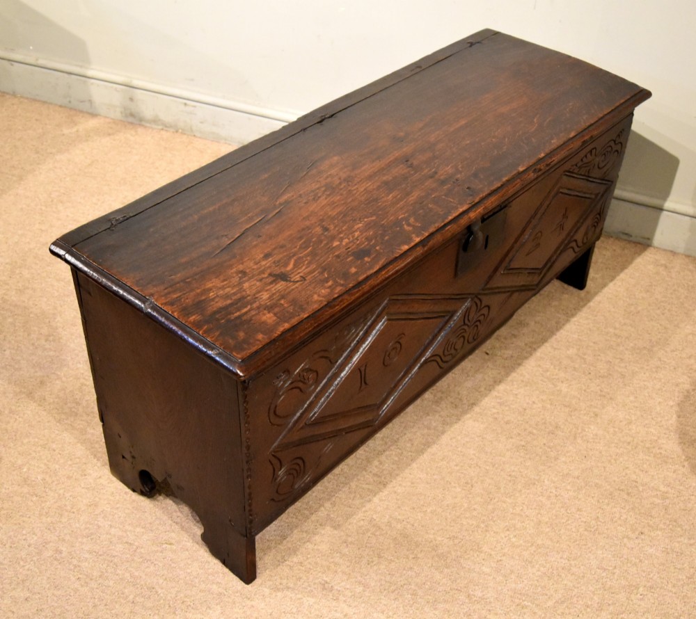A 17th-century dark oak six-plank coffer featuring carved lozenge patterns containing the date 1624 and a central iron lockplate. View IX