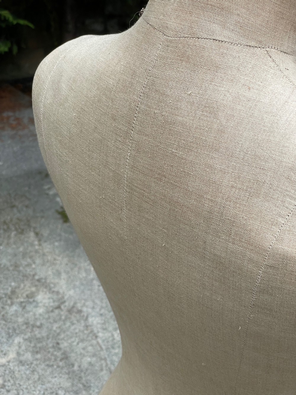 A fabric-covered female tailors dummy torso featuring stitched neutral linen upholstery and a dark turned neck finial. View XVIII