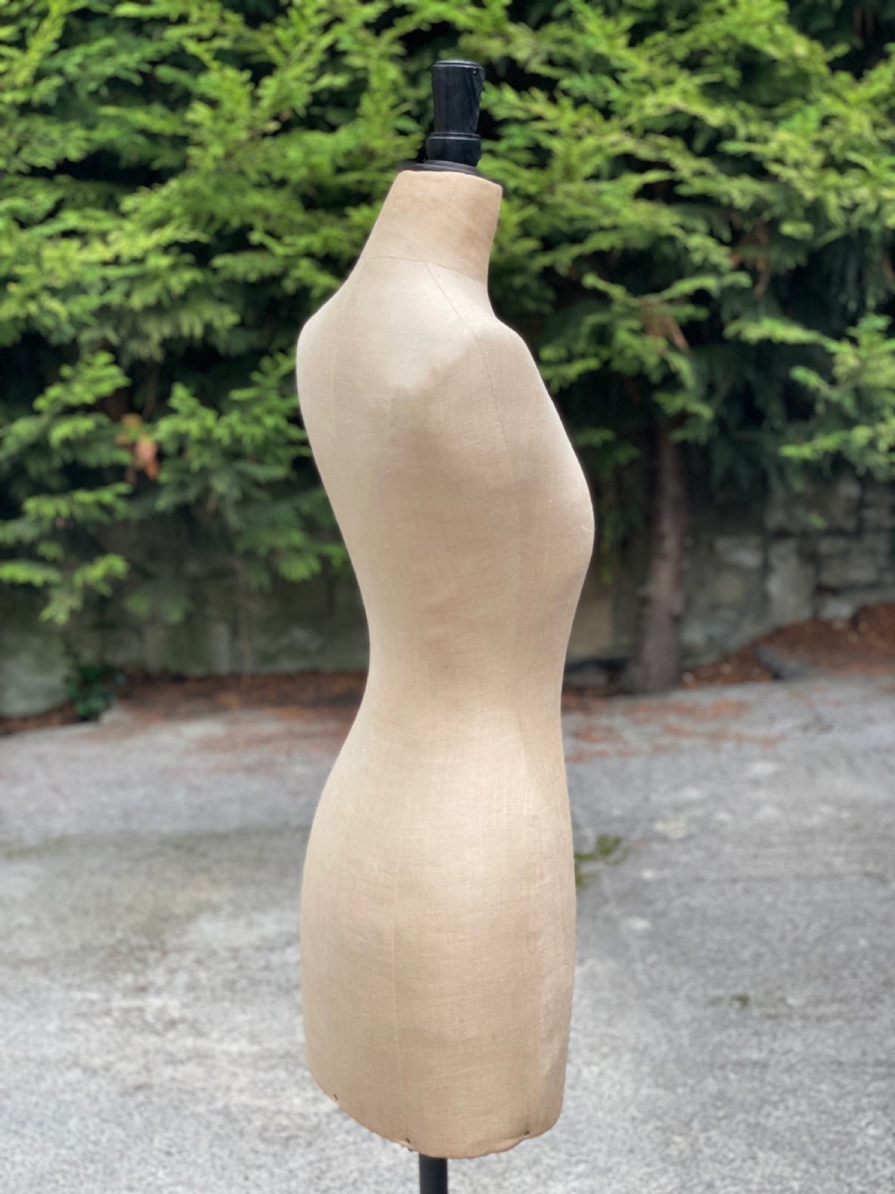 A fabric-covered female tailors dummy torso featuring stitched neutral linen upholstery and a dark turned neck finial. View XX