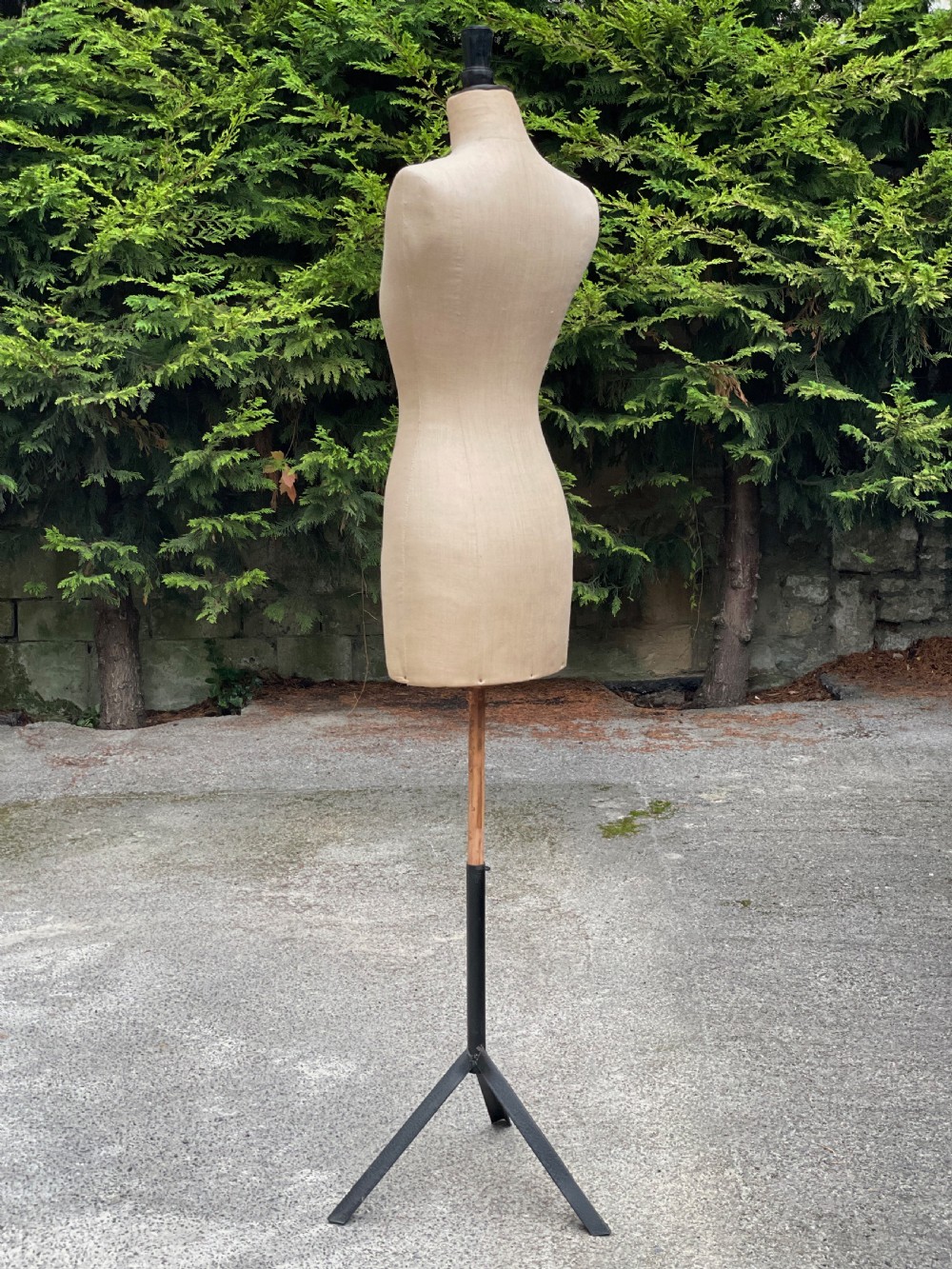 A fabric-covered female tailors dummy torso featuring stitched neutral linen upholstery and a dark turned neck finial. View XXI