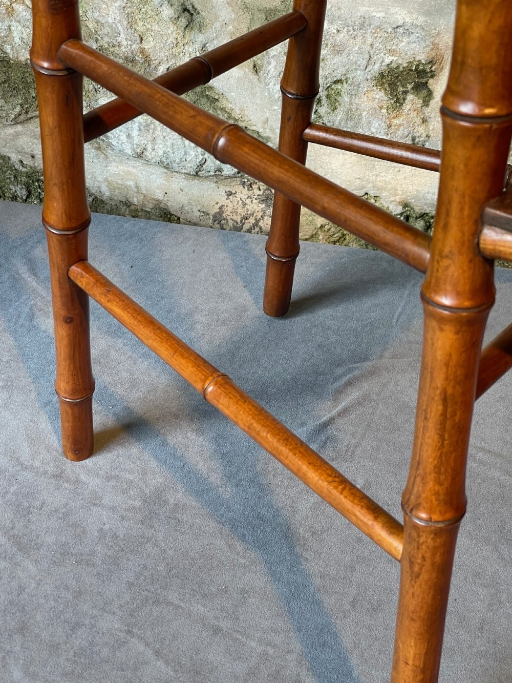An antique Victorian faux bamboo turned wood childs high chair featuring a woven cane seat and integrated footrest. View V
