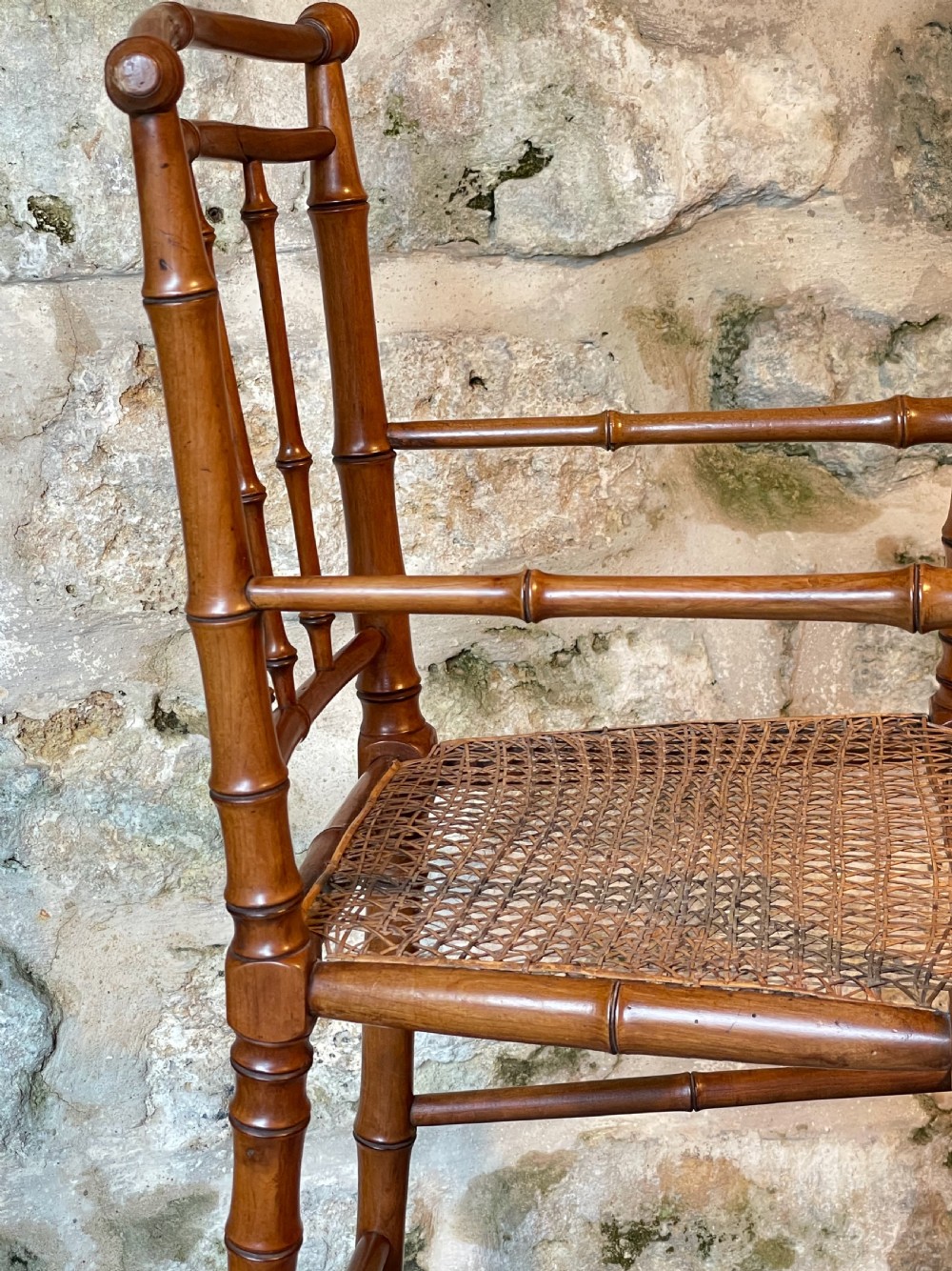 An antique Victorian faux bamboo turned wood childs high chair featuring a woven cane seat and integrated footrest. View VII