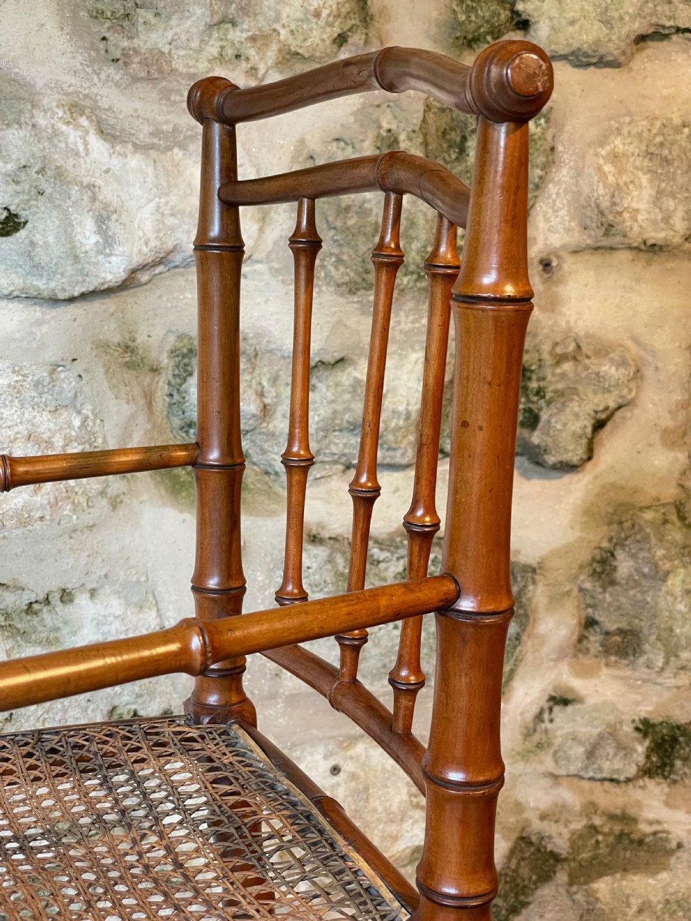 An antique Victorian faux bamboo turned wood childs high chair featuring a woven cane seat and integrated footrest. View XIII