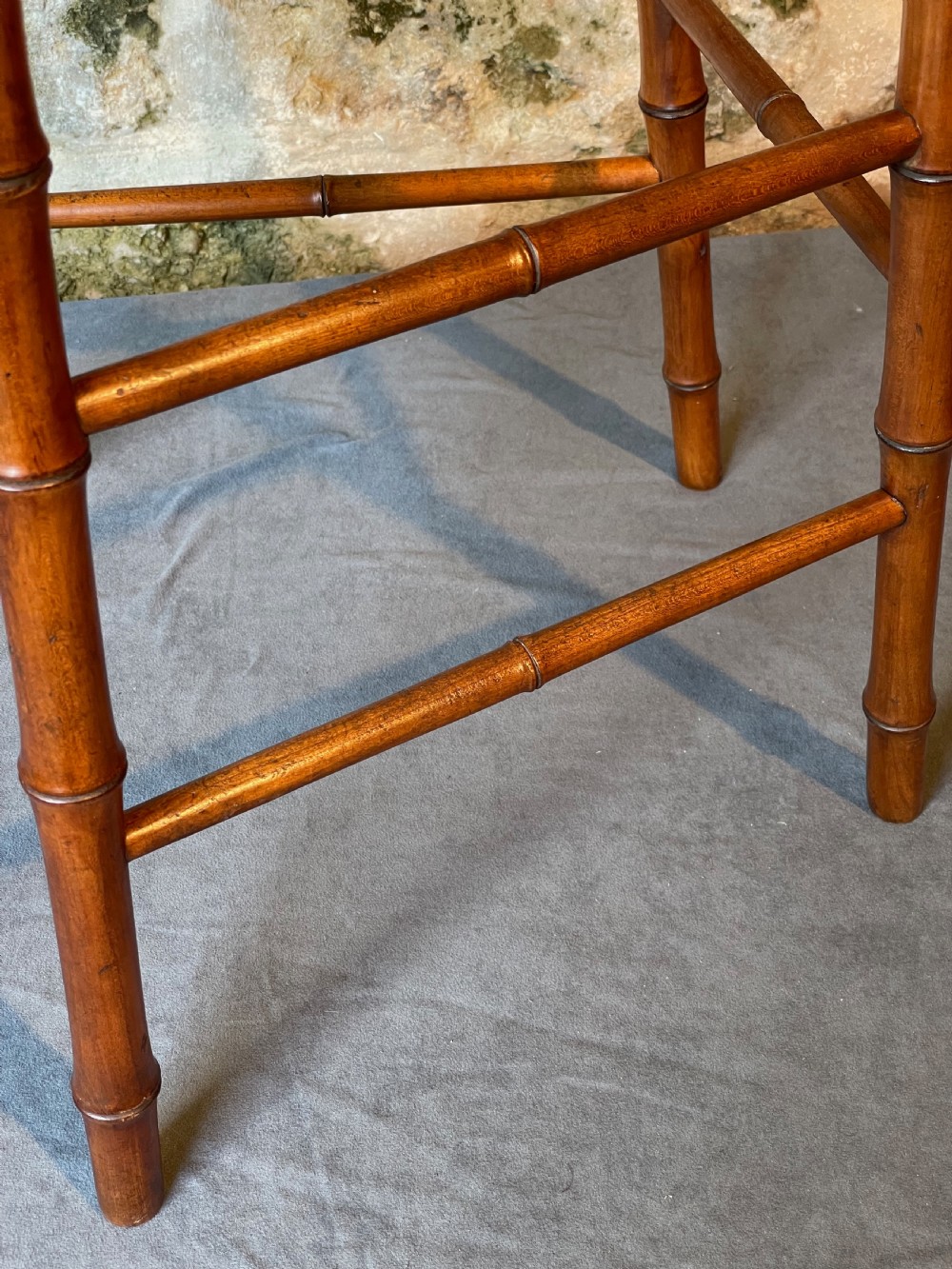 An antique Victorian faux bamboo turned wood childs high chair featuring a woven cane seat and integrated footrest. View XV