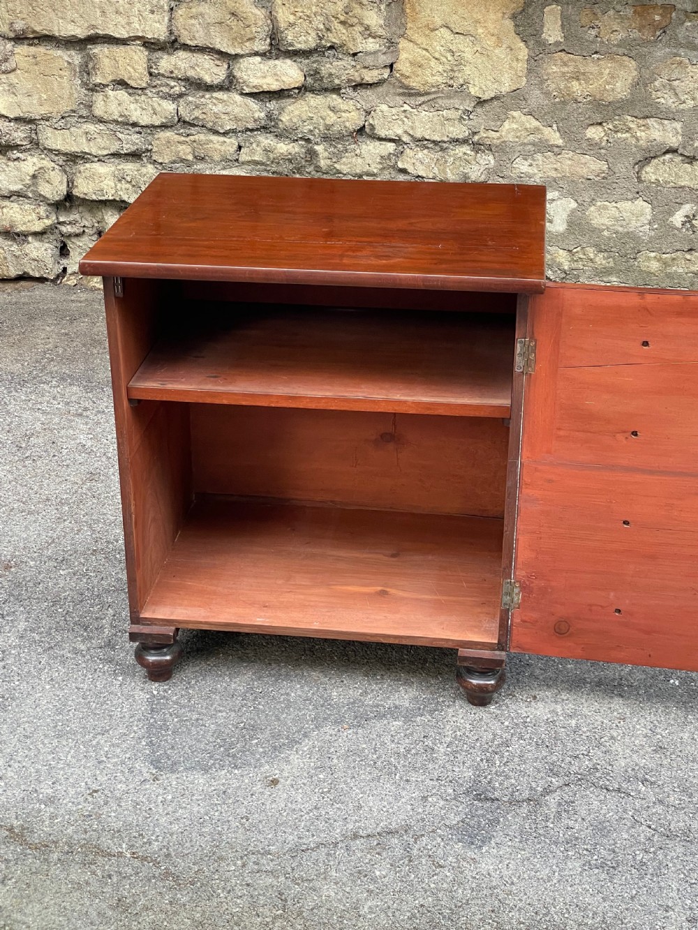 A Victorian warm brown wooden chest featuring four horizontal drawers with matching wooden knob handles and turned feet. View II