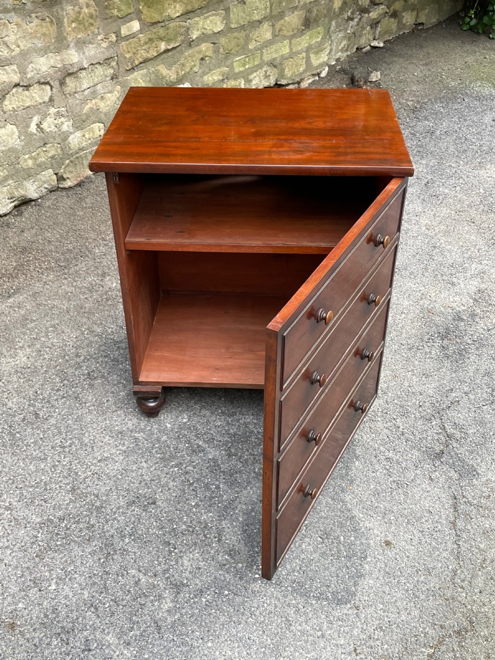A Victorian warm brown wooden chest featuring four horizontal drawers with matching wooden knob handles and turned feet. View IV