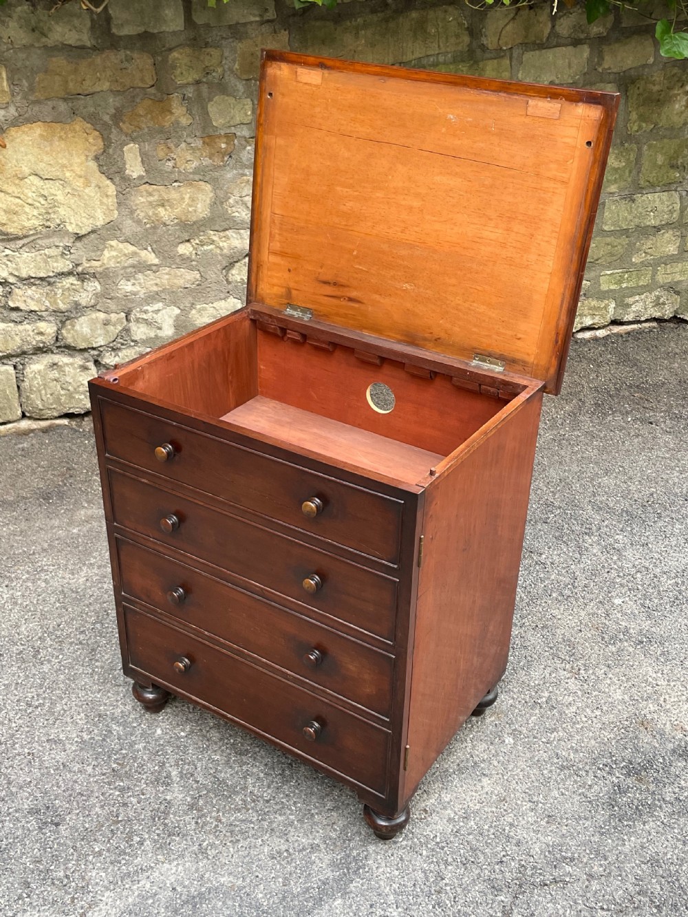 A Victorian warm brown wooden chest featuring four horizontal drawers with matching wooden knob handles and turned feet. View VI