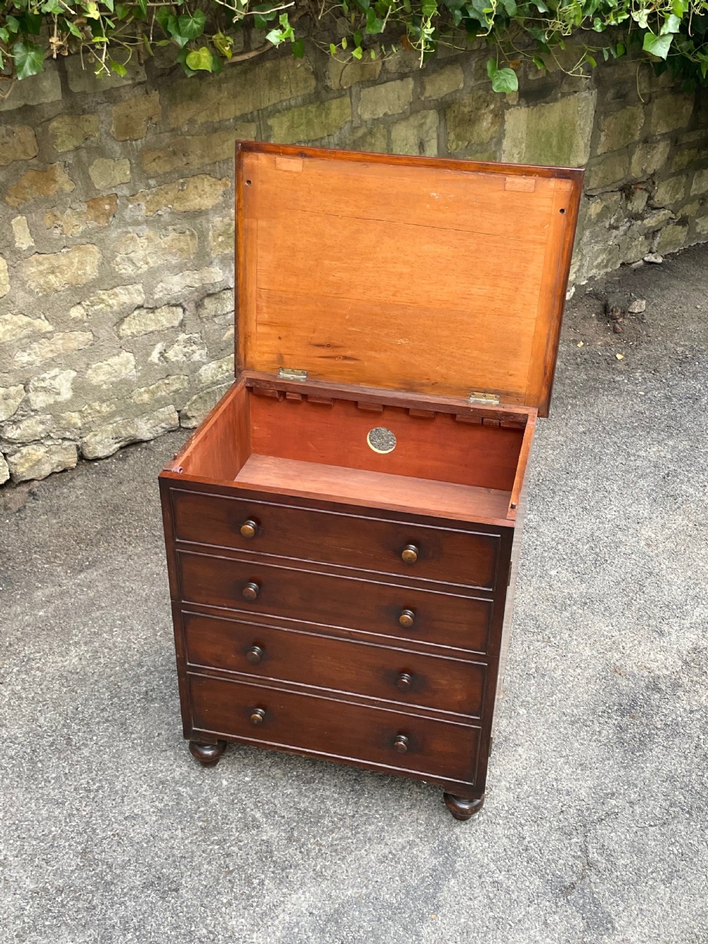 A Victorian warm brown wooden chest featuring four horizontal drawers with matching wooden knob handles and turned feet. View VII