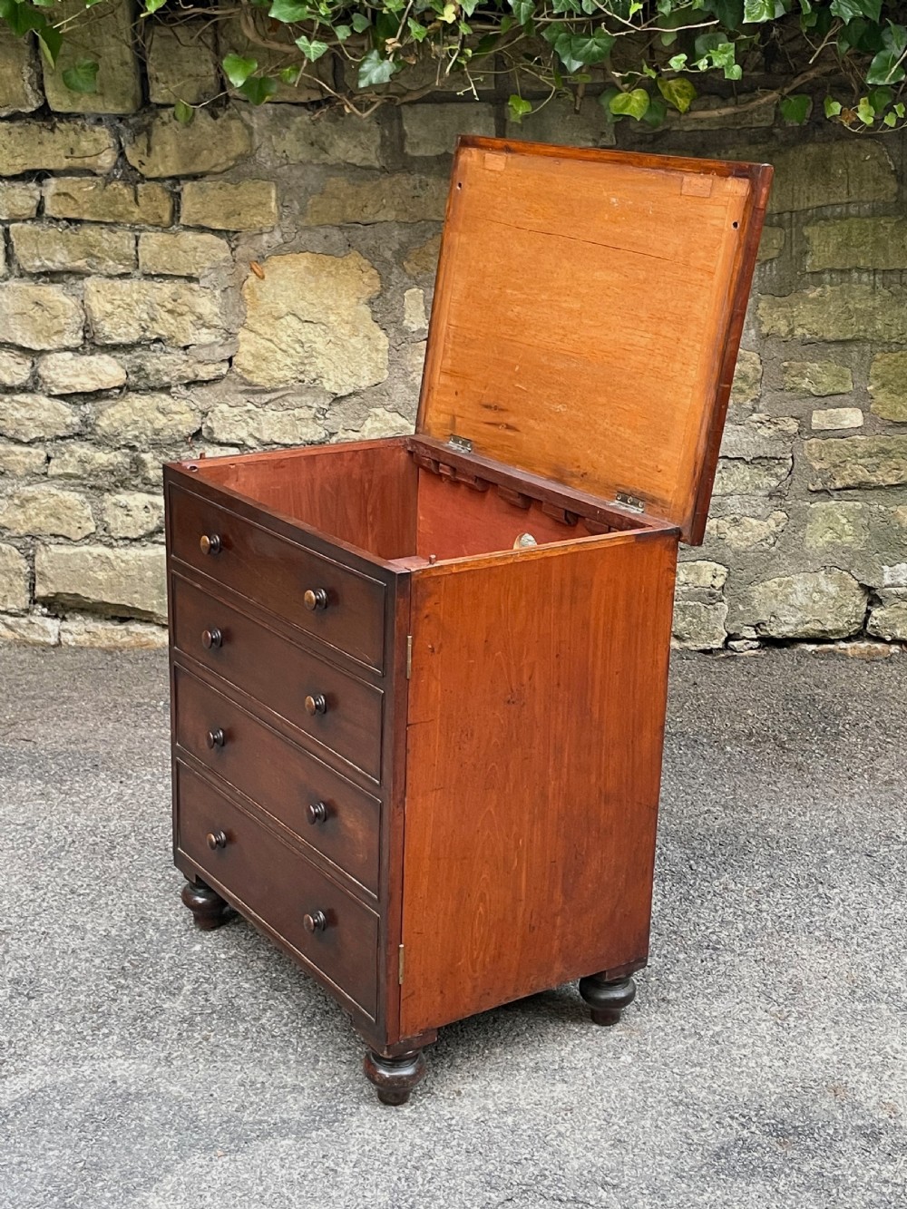 A Victorian warm brown wooden chest featuring four horizontal drawers with matching wooden knob handles and turned feet. View VIII