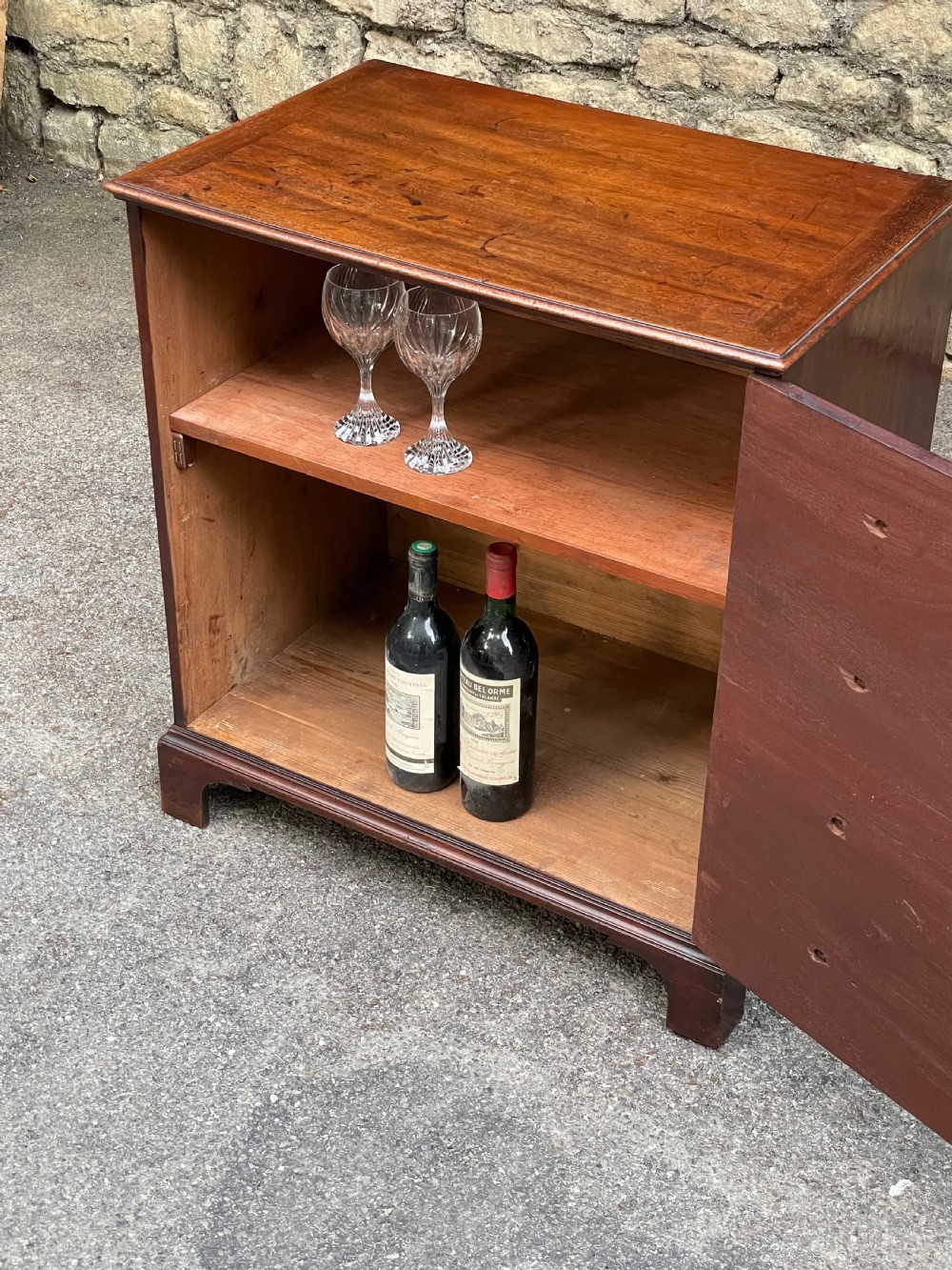 A Georgian mahogany chest featuring four drawer fronts with turned wooden handles and bracket feet. View XI