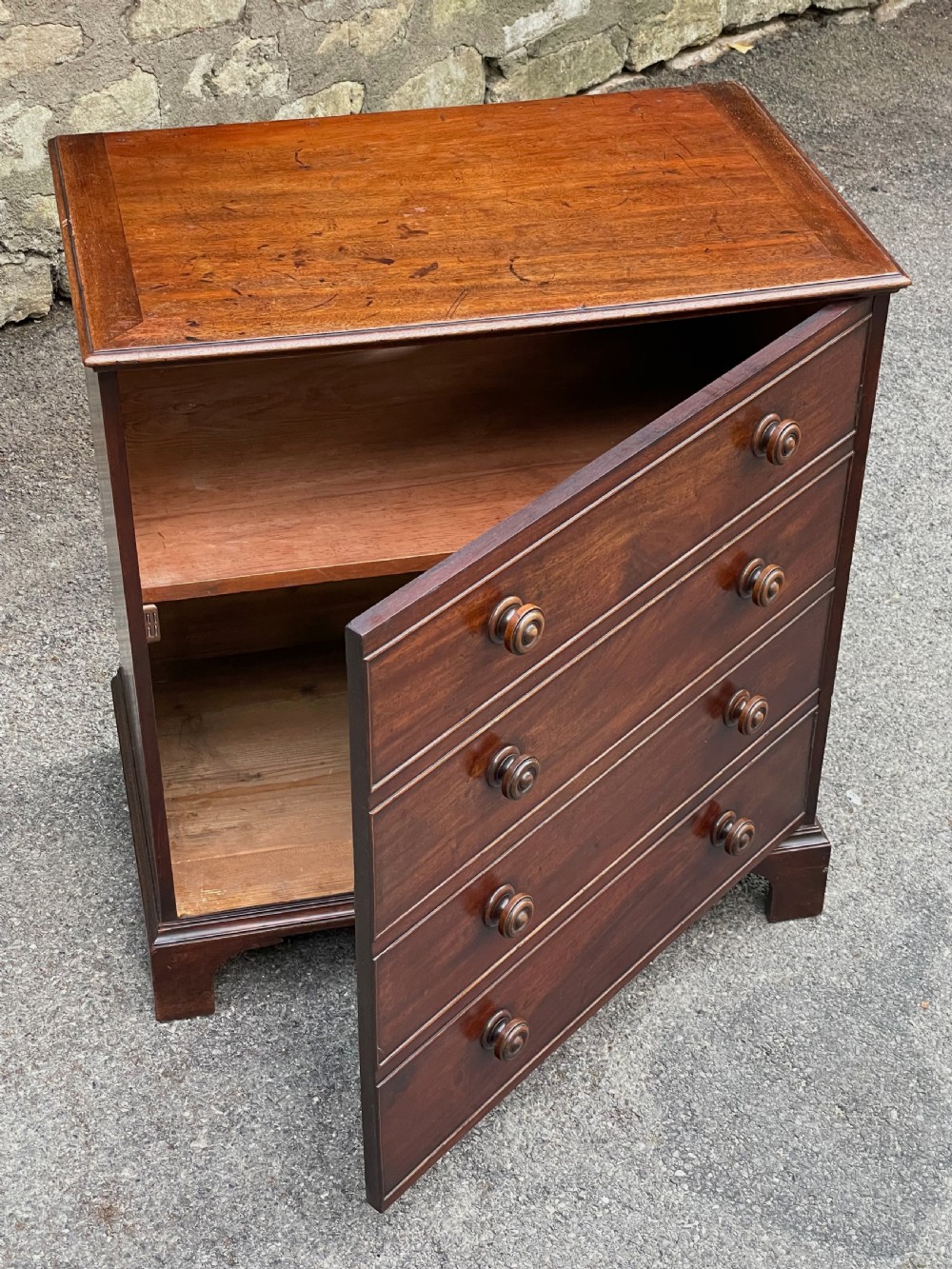 A Georgian mahogany chest featuring four drawer fronts with turned wooden handles and bracket feet. View XIII