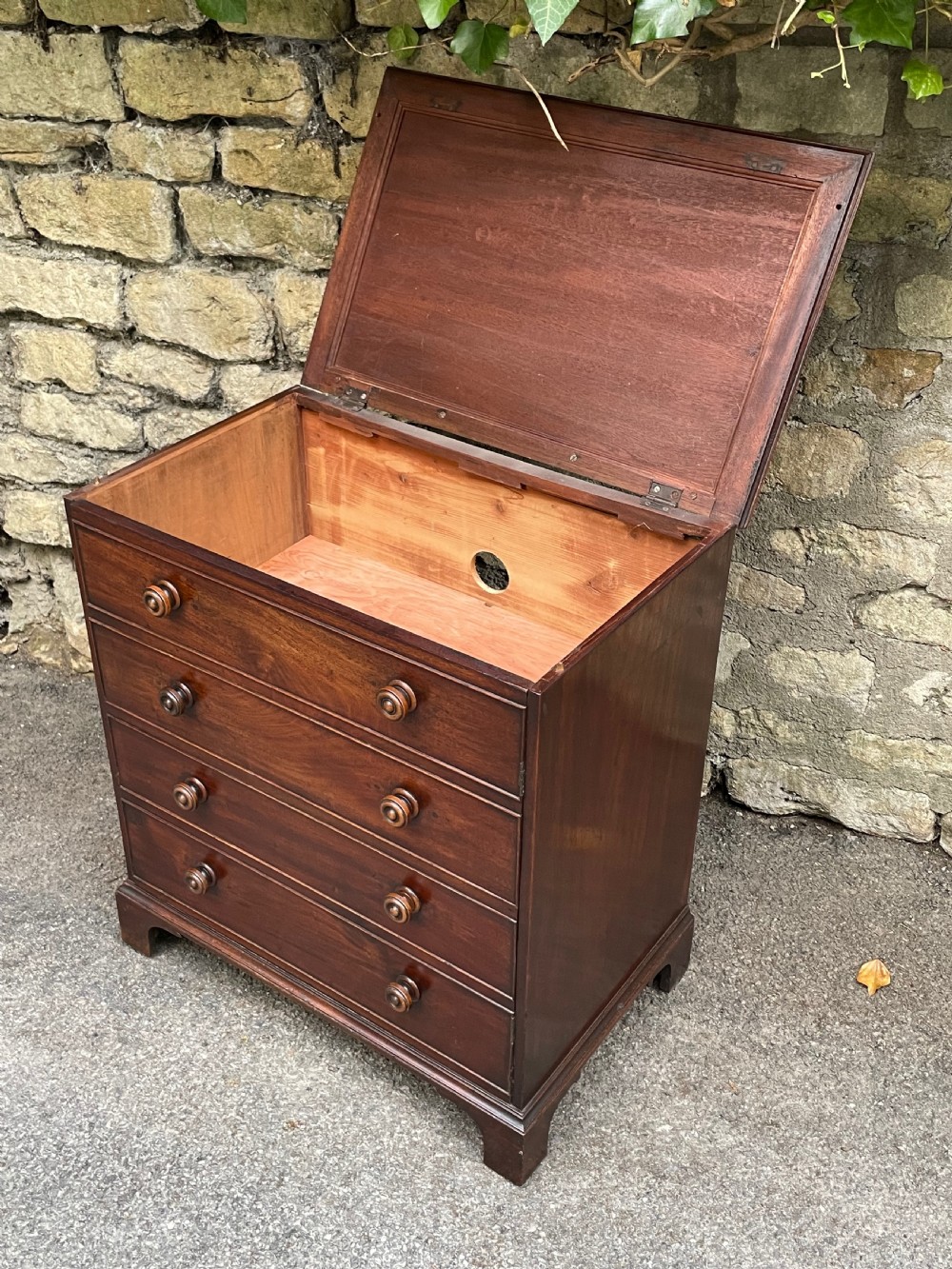 A Georgian mahogany chest featuring four drawer fronts with turned wooden handles and bracket feet. View XV