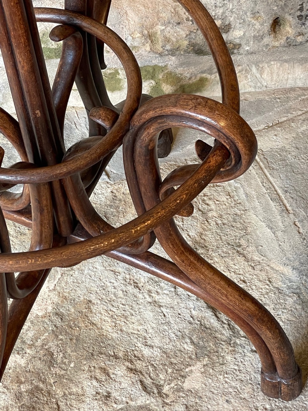 A dark brown bentwood hall stand featuring scrolled upper hooks for hats and coats, a central pole, and a curved lower frame for umbrellas. View IX