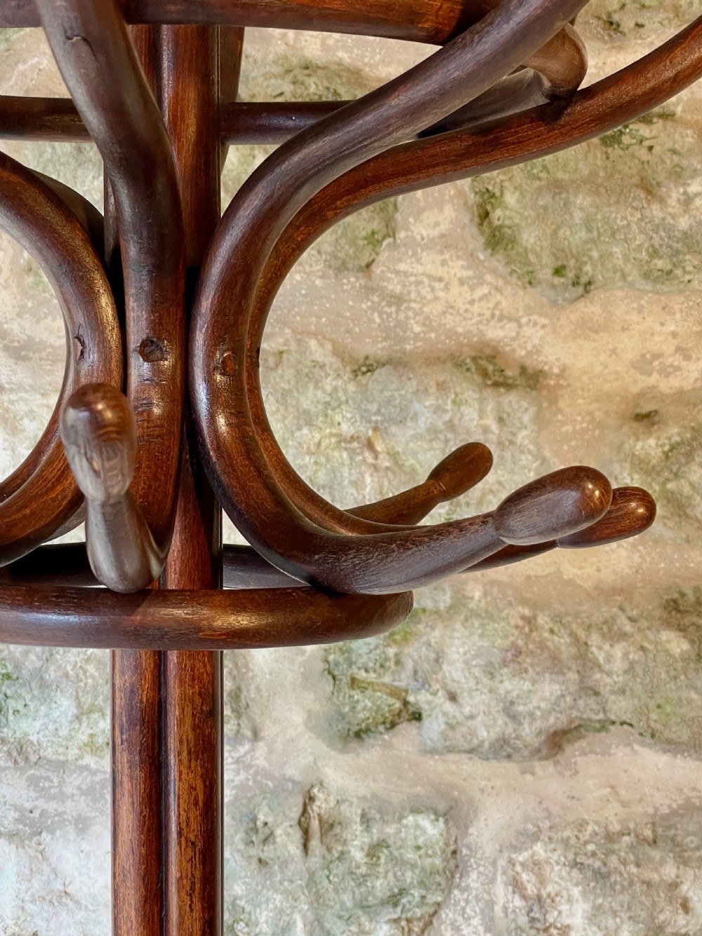 A dark brown bentwood hall stand featuring scrolled upper hooks for hats and coats, a central pole, and a curved lower frame for umbrellas. View XIV