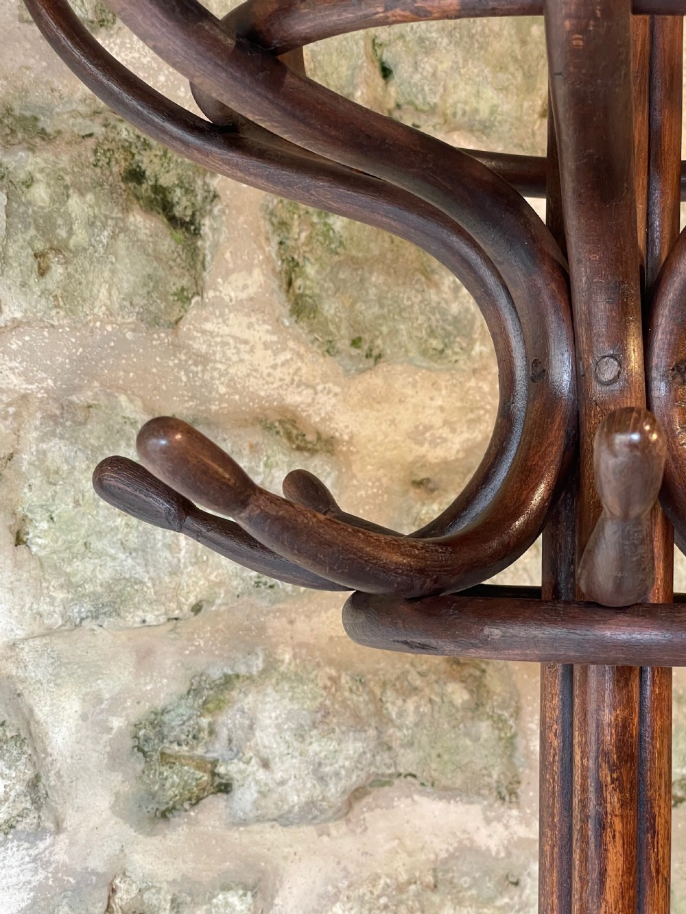 A dark brown bentwood hall stand featuring scrolled upper hooks for hats and coats, a central pole, and a curved lower frame for umbrellas. View XV