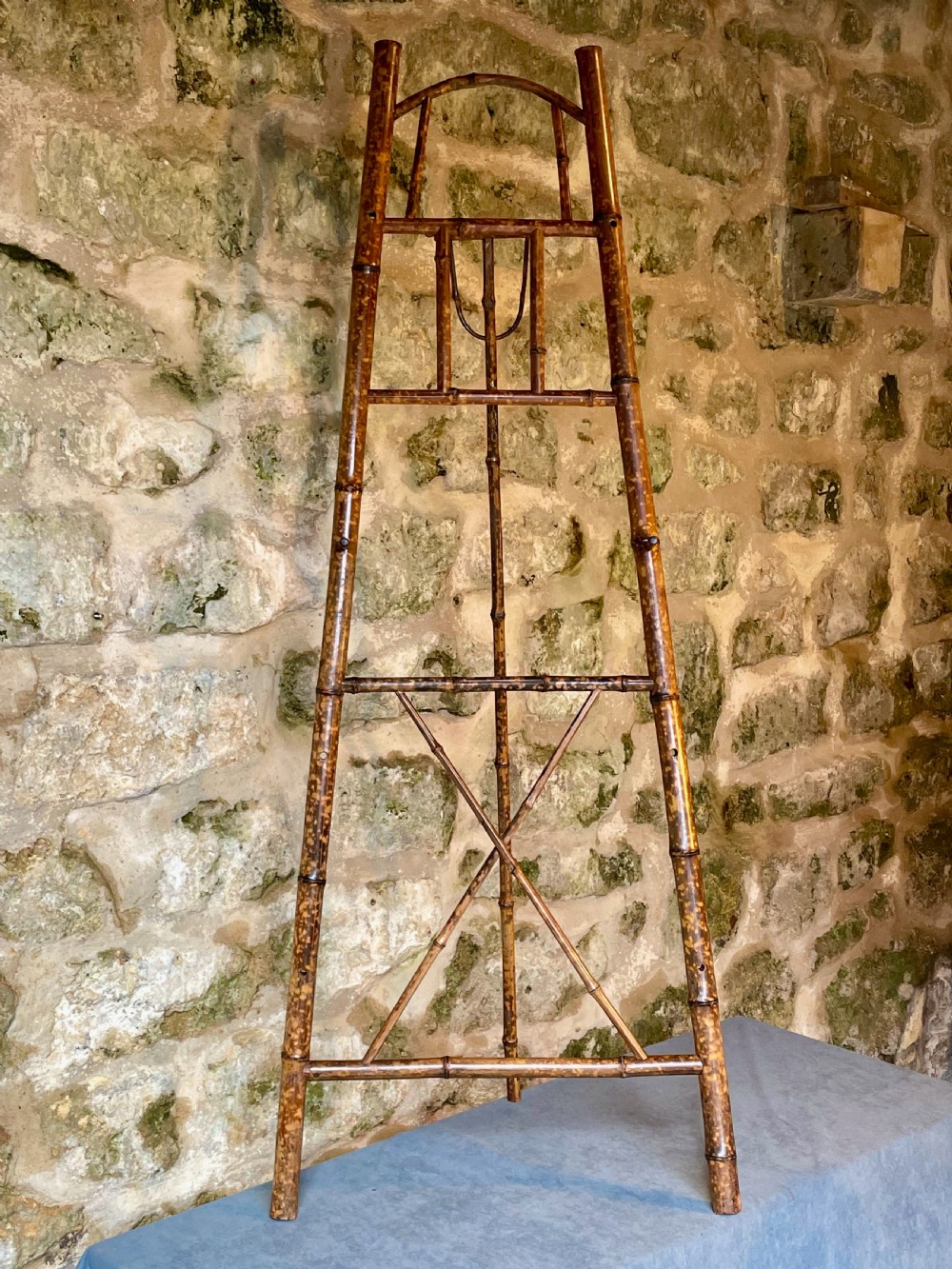 A tall Victorian freestanding easel crafted from mottled brown bamboo with cross-bracing and support pegs. View III