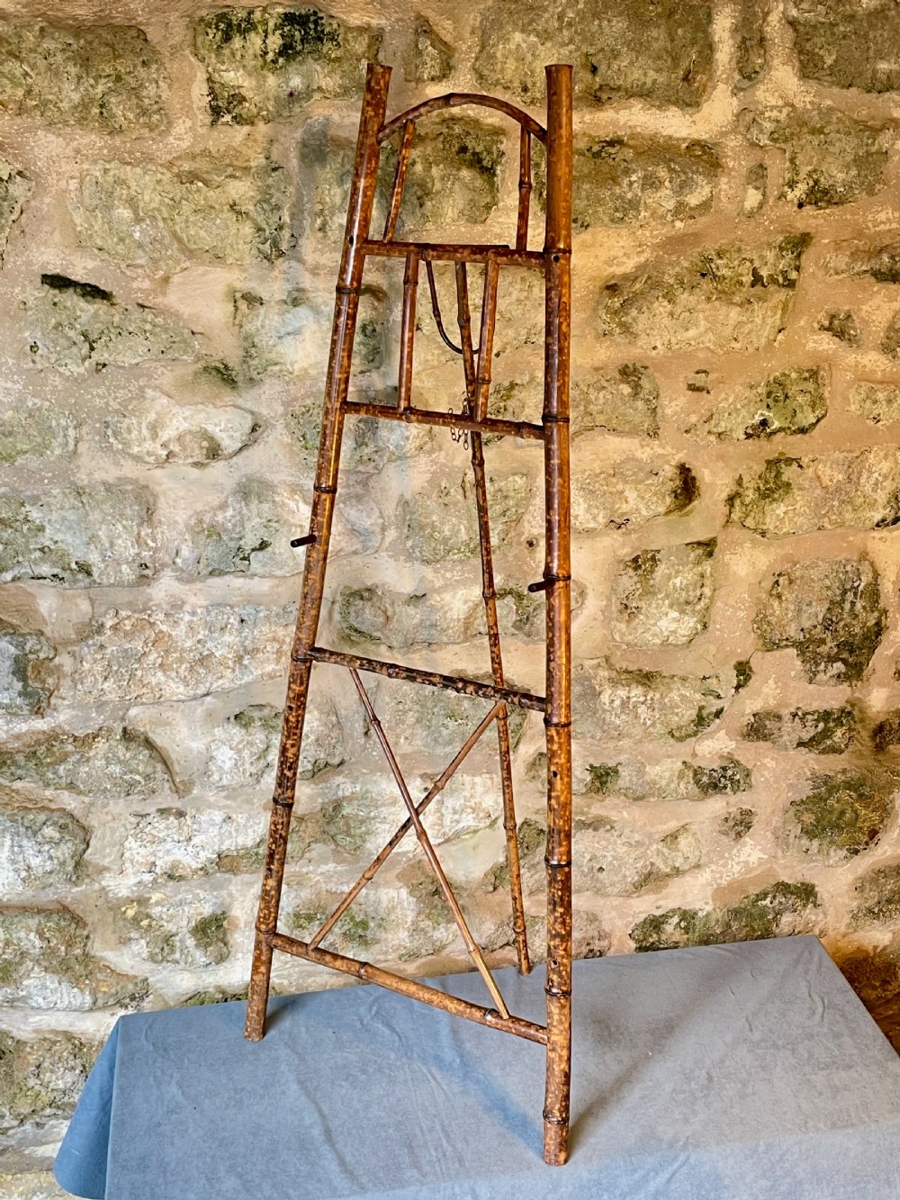 A tall Victorian freestanding easel crafted from mottled brown bamboo with cross-bracing and support pegs. View IV
