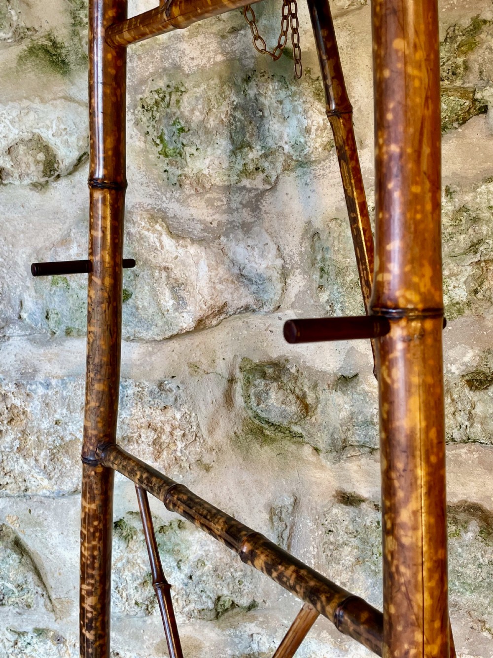 A tall Victorian freestanding easel crafted from mottled brown bamboo with cross-bracing and support pegs. View V