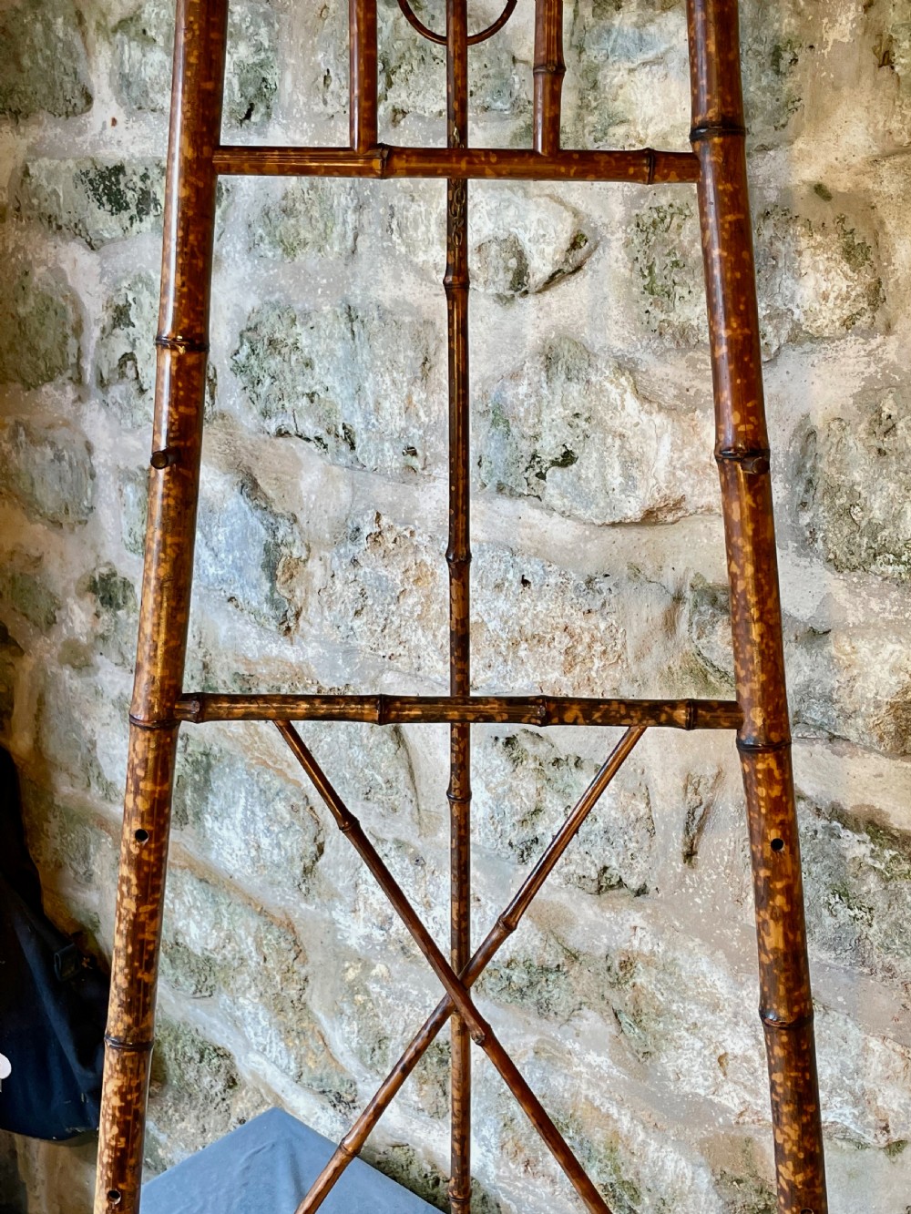 A tall Victorian freestanding easel crafted from mottled brown bamboo with cross-bracing and support pegs. View IX