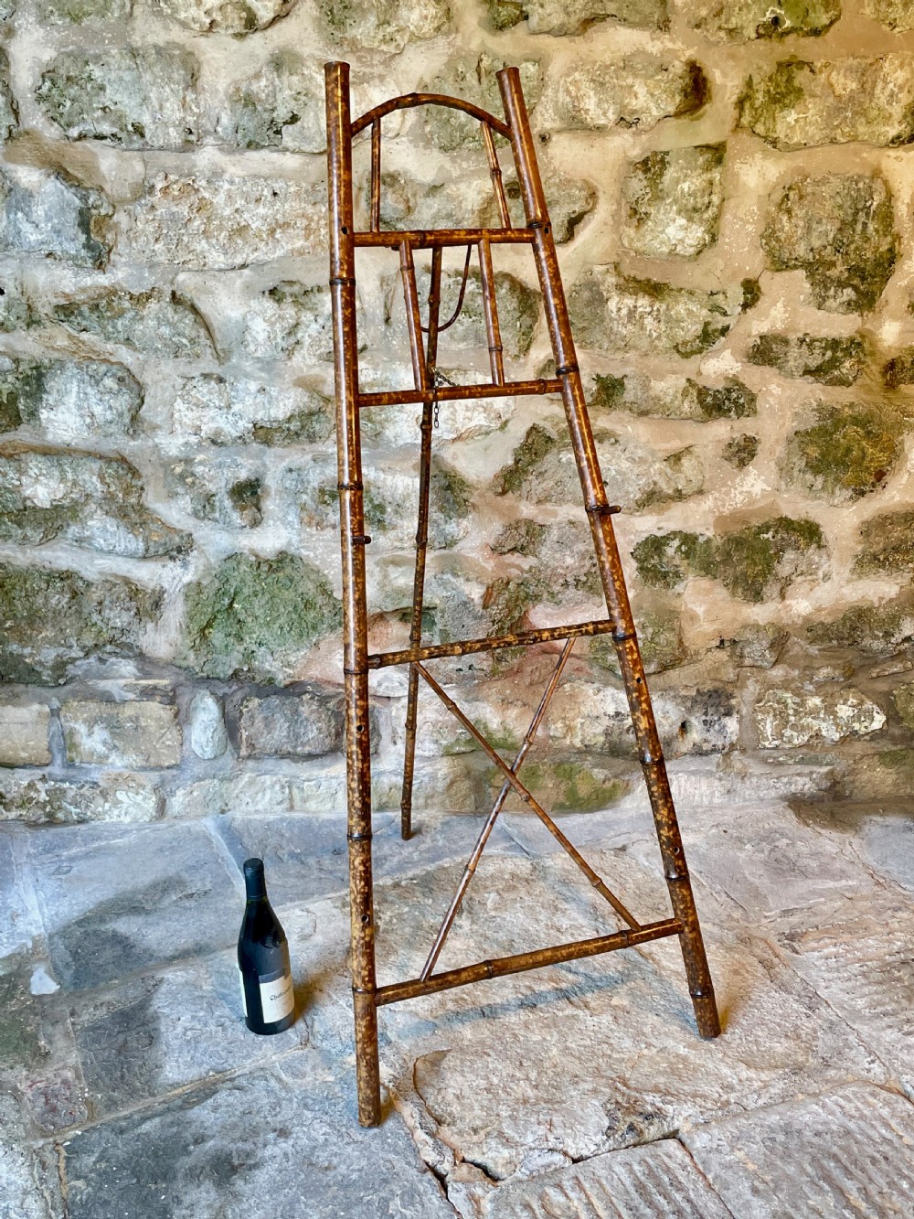 A tall Victorian freestanding easel crafted from mottled brown bamboo with cross-bracing and support pegs. View XV