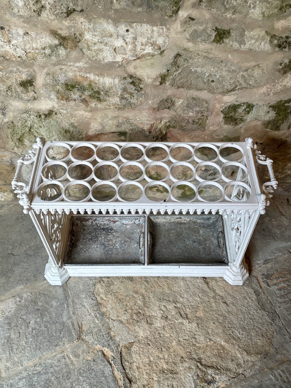 A white painted cast iron stick stand featuring openwork Gothic tracery side panels, a circular grid top section, and a removable double drip tray. View XIII