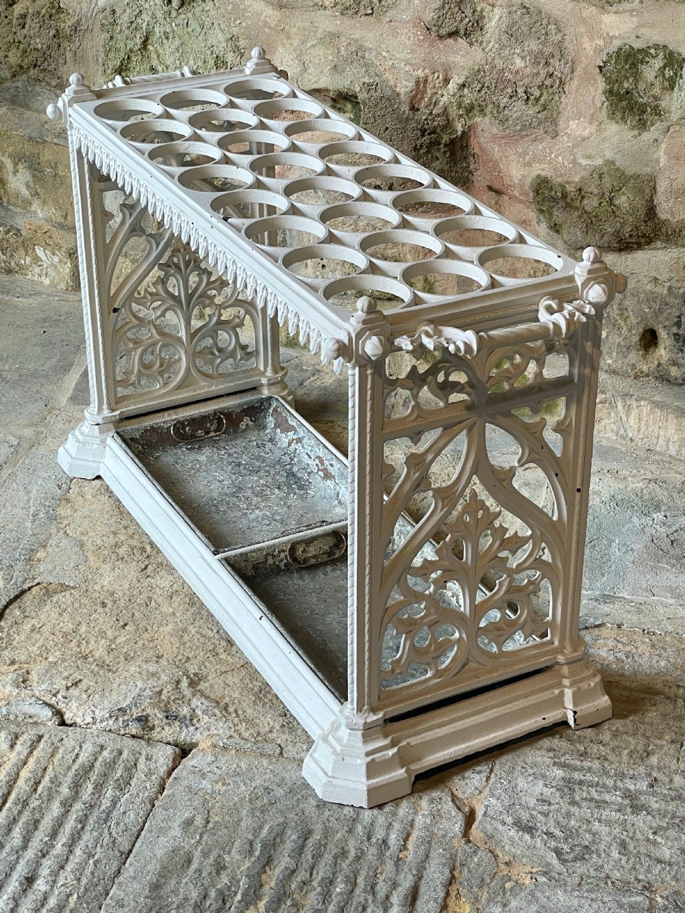 A white painted cast iron stick stand featuring openwork Gothic tracery side panels, a circular grid top section, and a removable double drip tray. View XIV
