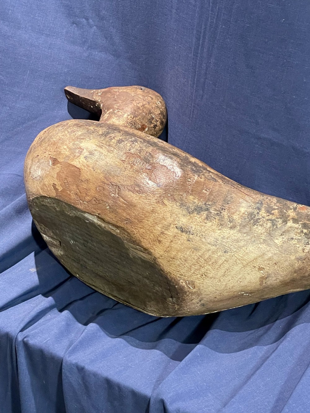 A hand-carved wooden decoy duck featuring a rounded body, defined head, and visible wood grain patination across the natural timber surface. View VIII