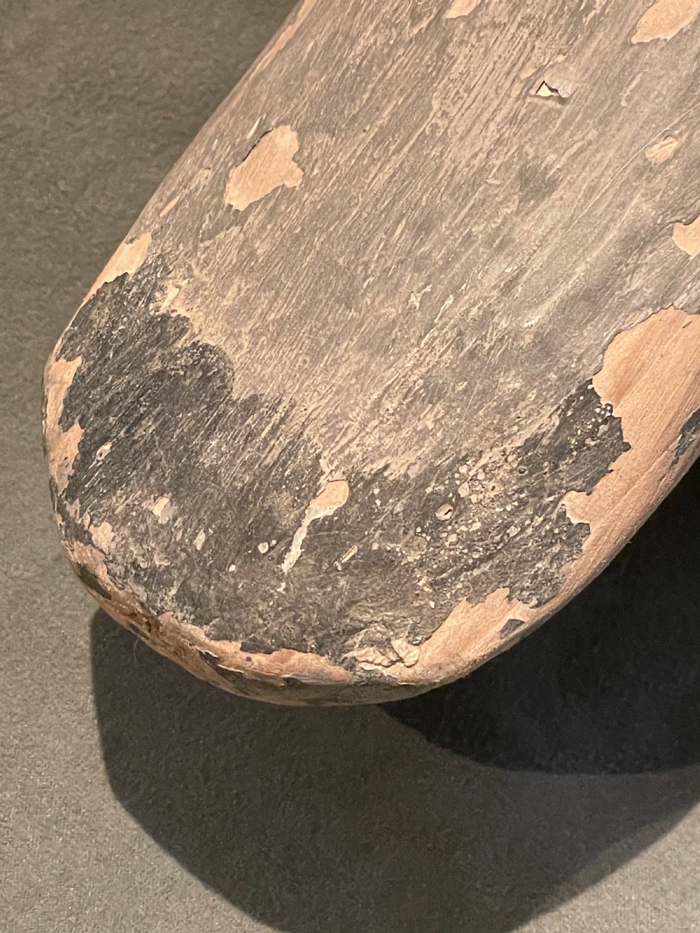 A hand-carved wooden pigeon decoy featuring weathered grey paint, mounted on a small rectangular wooden block. View XIII