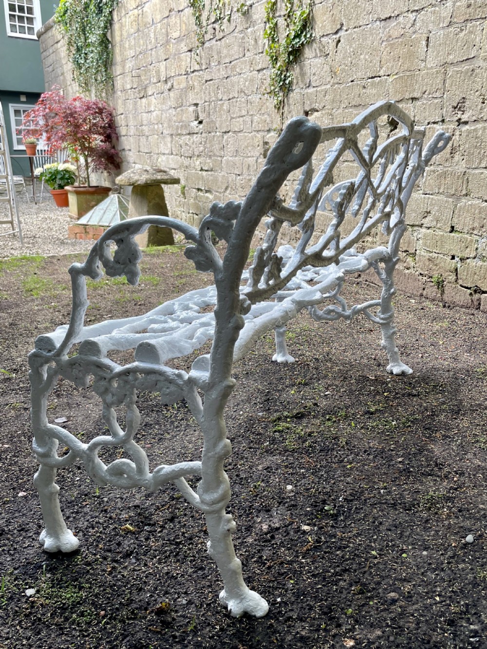 A painted white Victorian cast iron garden bench featuring an intricate intertwined branch and twig motif. View V