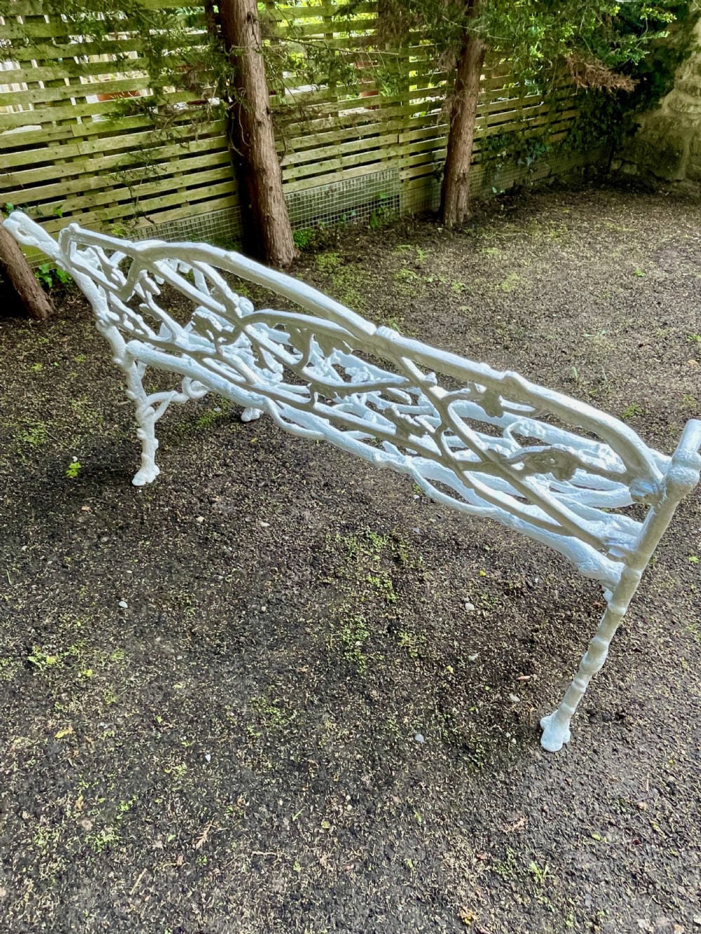 A painted white Victorian cast iron garden bench featuring an intricate intertwined branch and twig motif. View VII