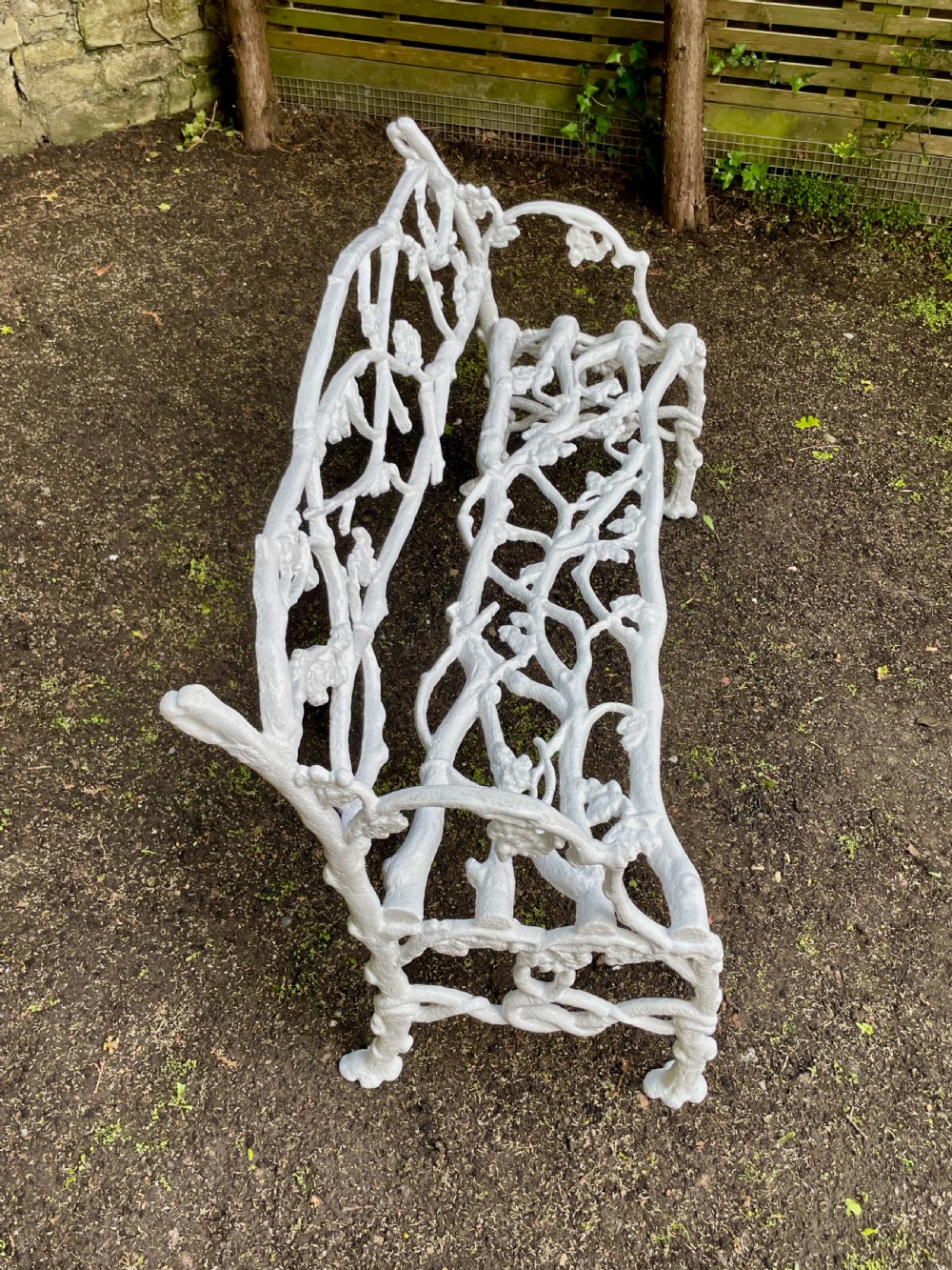A painted white Victorian cast iron garden bench featuring an intricate intertwined branch and twig motif. View VIII