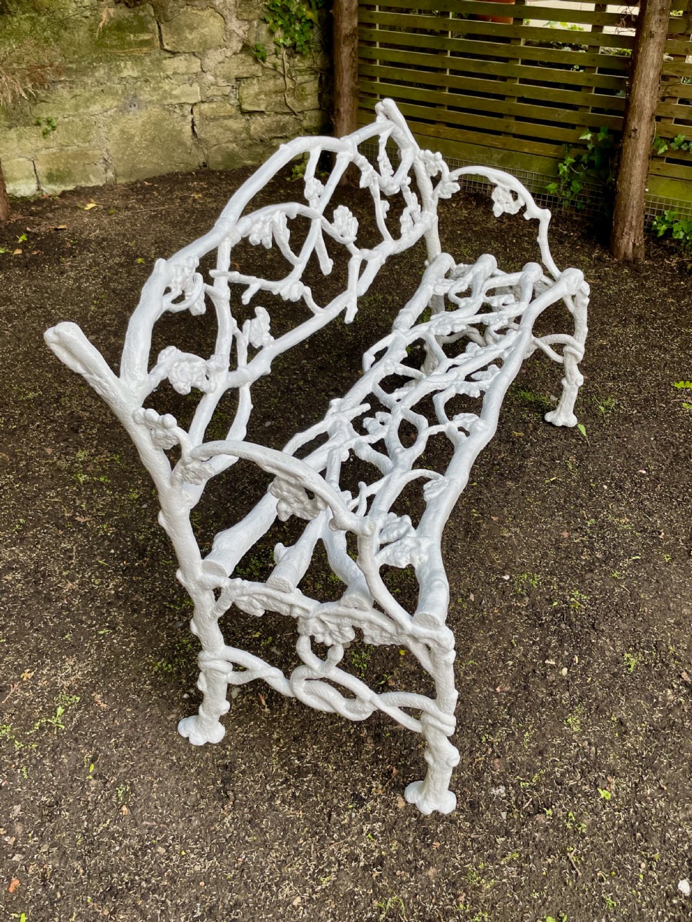 A painted white Victorian cast iron garden bench featuring an intricate intertwined branch and twig motif. View IX