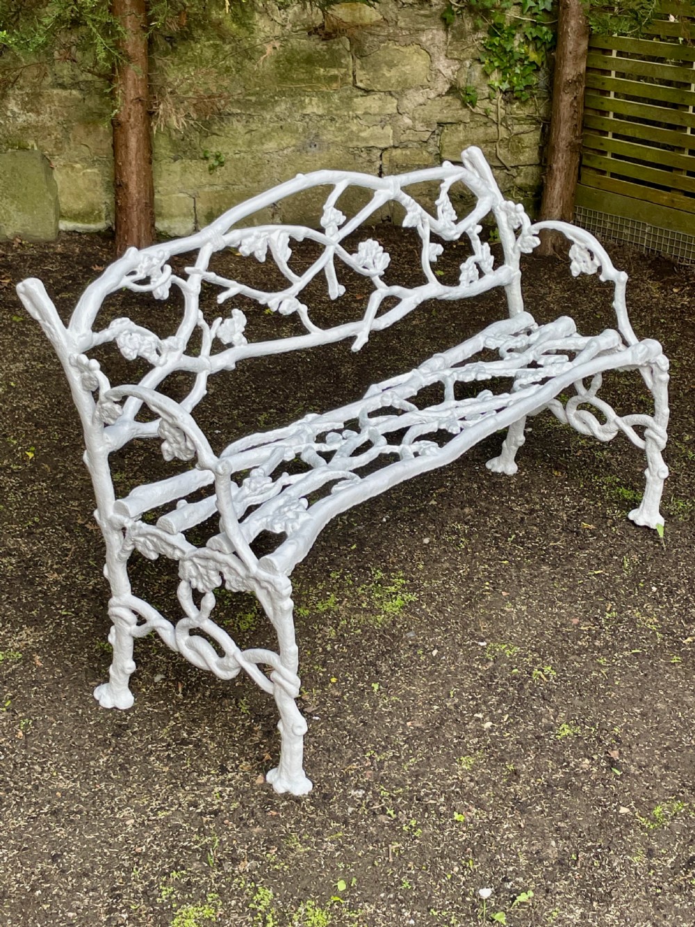 A painted white Victorian cast iron garden bench featuring an intricate intertwined branch and twig motif. View X