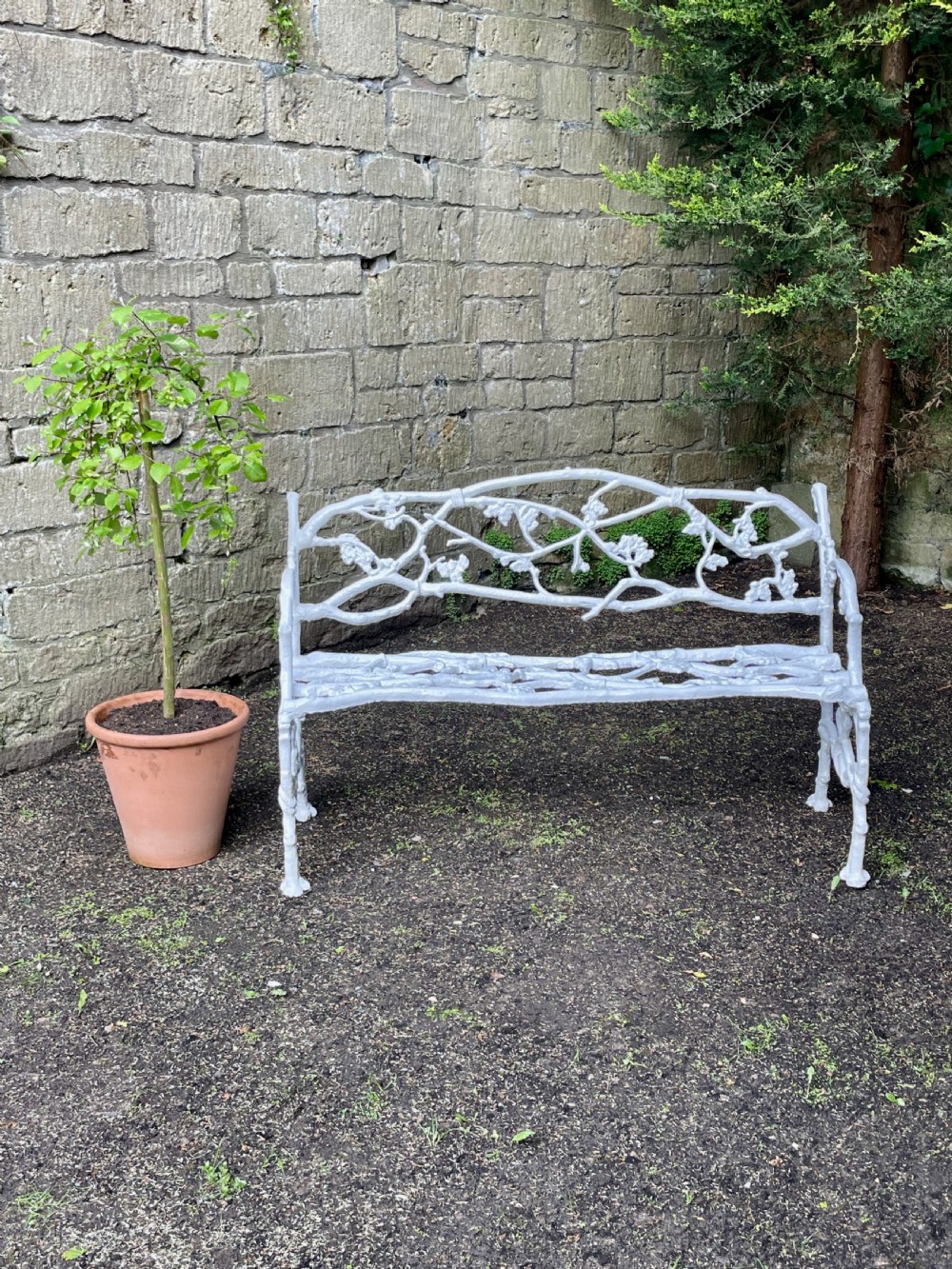 A painted white Victorian cast iron garden bench featuring an intricate intertwined branch and twig motif. View XII